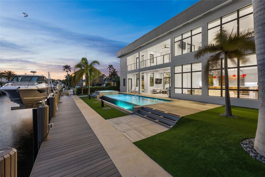 Experience unparalleled luxury just moments from the open ocean! This modern estate offers 80’ of prime waterfront with no fixed bridges, ensuring convenient access to the Hillsboro Inlet, Lake Boca & the Boca Inlet. A custom pivot door welcomes you into soaring ceilings and an open-concept layout that flows effortlessly into your outdoor oasis, featuring a resort-style infinity pool, spa & summer kitchen. The chef’s kitchen is highlighted by sleek Scavolini Italian cabinetry, premium Wolf & Miele appliances, and a large 13’ island with built-in wine fridge. Enjoy your morning coffee from the 2nd floor balcony right off your large primary suite. This is more than a home—it’s a lifestyle reserved for the most discerning buyer! Other notable features include 20,000 lb boat lift and elevator.