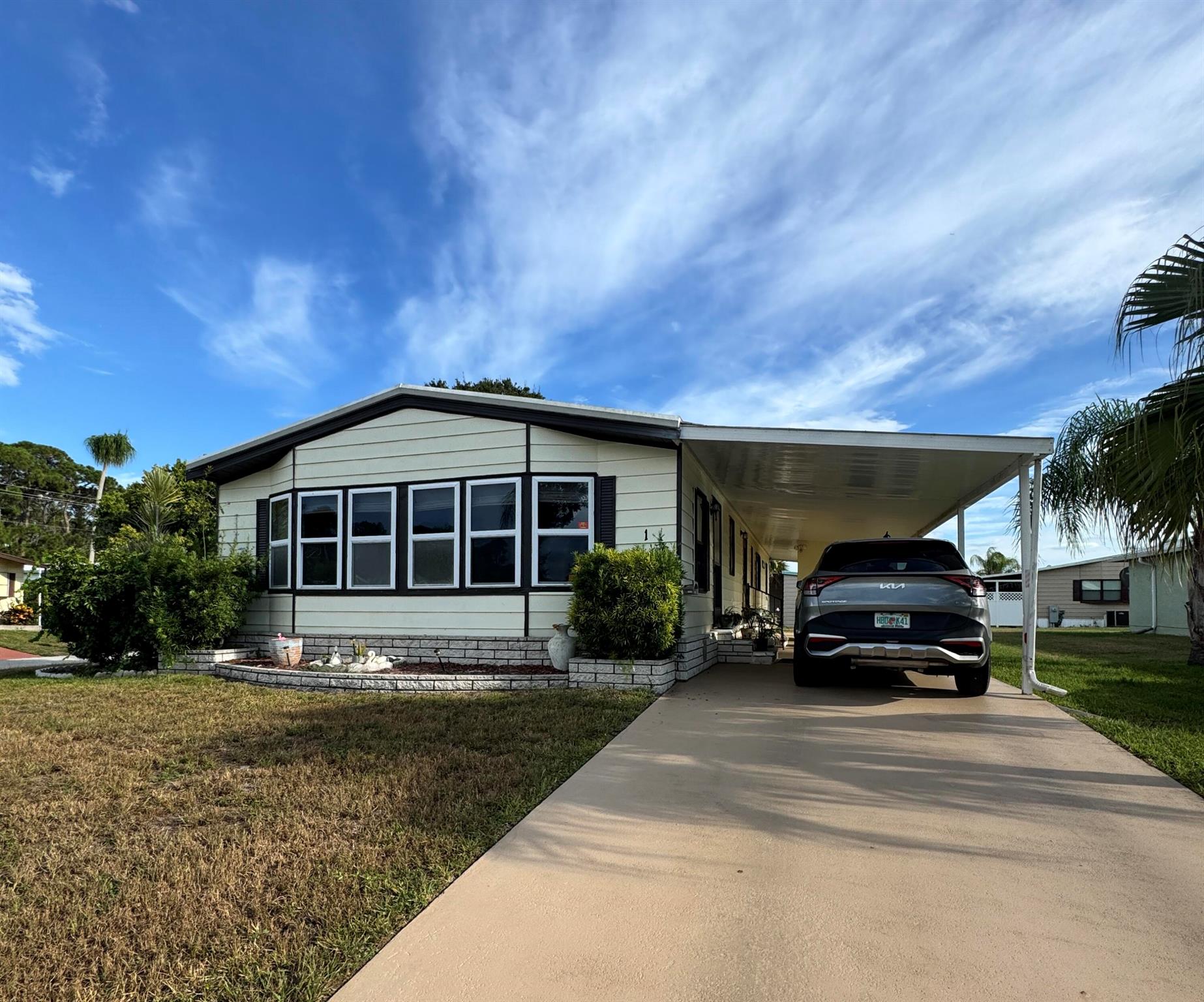 Lovely 2-bedroom 2-bath home in the desirable Spanish Lakes Country Club Village 55 plus community. Home sits on a corner lot on a quiet cal da sac. The house has an open kitchen with an island and bar with extra seating. The dining room has built-in shelves for added storage. The living room has built-in shelves as well. Laundry is inside the home--a large Florida room with ceramic tile and wrap-around windows: laminate flooring, no carpet. Lawn care and trash removal are included in the lot rent. The property features two pools, tennis, pickleball, bocceball, and shuffleboard. clubhouse and much more.