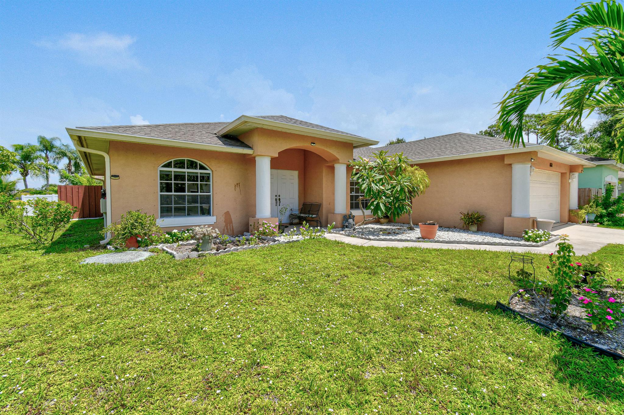 🌴 Tropical Retreat in South Port St. Lucie 🌴 Situated on a spacious corner lot, this charming South Port St. Lucie home is surrounded by lush tropical trees and vibrant landscaping that create a private oasis. Step through double entry doors into a bright, welcoming living space featuring an open split floor plan and gleaming tile throughout.The kitchen is a true highlight, with granite countertops, stainless steel appliances, and plenty of room to entertain. Step outside to a screened-in patio that overlooks a large, fenced backyard--perfect for relaxing, gardening, or gathering with friends.