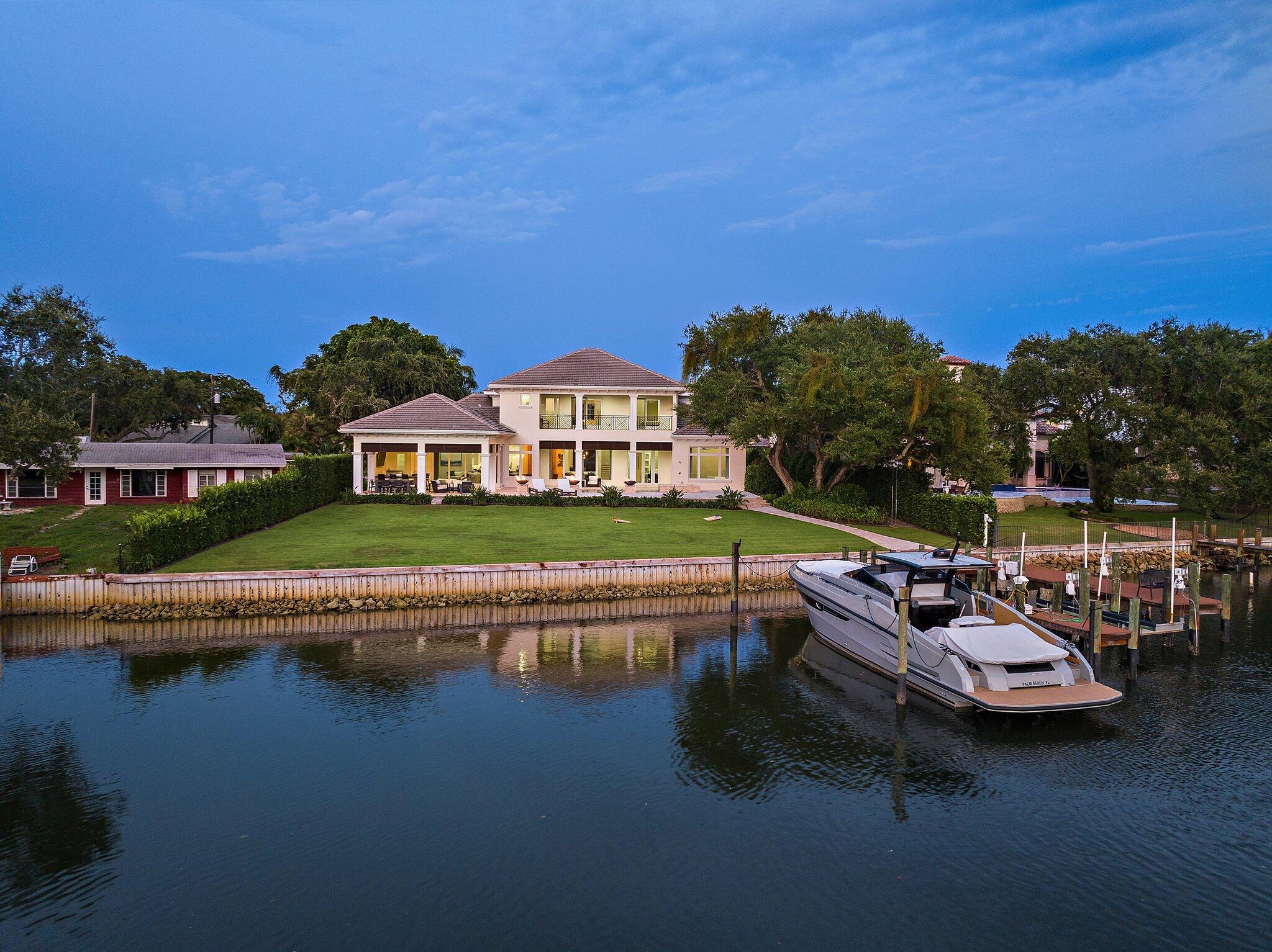 Welcome to your dream waterfront estate! This exquisite 5-bedroom + den, 6.5-bath residence is a masterpiece of luxury and comfort, nestled on over half an acre with 135 feet of direct Intracoastal Waterway frontage. Designed for the discerning homeowner, this property boasts a 4-car garage and a private dock with a 20,000 lb. lift--perfect for the yachting enthusiast, offering easy ocean access with no fixed bridges. Step inside to discover a chef's paradise in the gourmet kitchen, featuring a gas cooktop, expansive countertops, dual sinks, and a wine cooler, all adjacent to a cozy casual dining area. For more formal occasions, the elegant dining room awaits. The home also includes a family room and a formal living room, providing ample space for entertaining. Plus, there's a wine room.