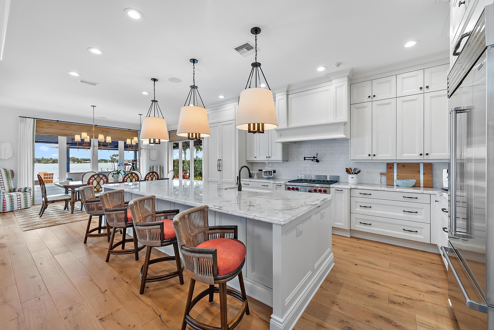 This privated and gated riverfront retreat will take your breath away- where luxury meets lifestyle on the widest stretch of the Loxahatchee River. This beautifully furnished 3-bedroom, 4-bath estate features king suites throughout, along with a dedicated office, media room, and home gym--designed with both comfort and sophistication in mind.Professionally decorated and styled with high-end finishes, the home includes a chef's kitchen, an expansive primary suite with a custom walk-in closet, ideal for anyone undergoing a home renovation or in search of a seasonal escape.Step outside to your own resort-style retreat: pool, hot tub, full summer kitchen and outdoor ultimate entertaining space. Private dock includes 1 boat slip with lift.