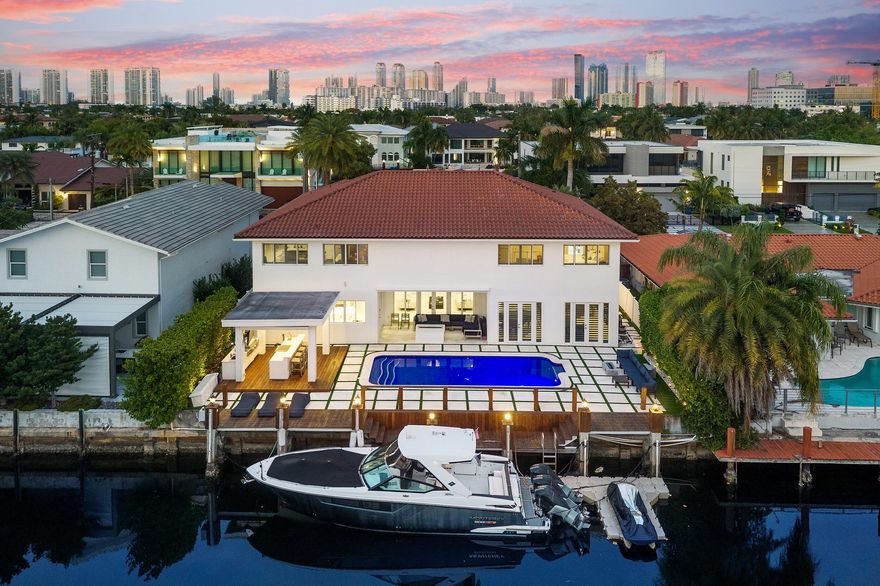 Welcome to the Prestigious gated community of Eastern Shores! Don't miss this Spectacular WATERFRONT property in the heart of North Miami Beach. Upon entering this pristine home you will be captivated by the 20 ft ceilings with a large bright and open living area looking directly out to phenomenal views of the water. This 5127 sq feet single family home includes 5 bedrooms, 4.5 bathrooms and a separate den and dining area. Flooring is made of 4 by 4 stunning porcelain tile.  Off of the living area is a beautiful glass enclosed temperature controlled wine room. The home offers incredible closet space including a 400 square foot extension for storage/ possible office. The Primary Suite includes an expansive bathroom with an extra large shower that leads to a private glass enclosed full gym. Impact Windows and doors throughout (excluding one window above the front door)  Laundry includes 2 newer double washers and dryers. The kitchen includes highly updated appliances and leads directly out to a covered patio. This separate patio with a gas fireplace allows you to sit and take in breathtaking sunsets from your private Miami Gem.  Enjoy the waterfront backyard with a gorgeous heated glass tiled saltwater pool in addition to a built in summer kitchen area.  The newly updated deck is made of stunning rich colored wood with cement and turf decorative blocks leading to a 75 foot private dock. Eastern Shores provides direct access to the Intracoastal Waterways and the Atlantic ocean making this property a Boater's Dream!!