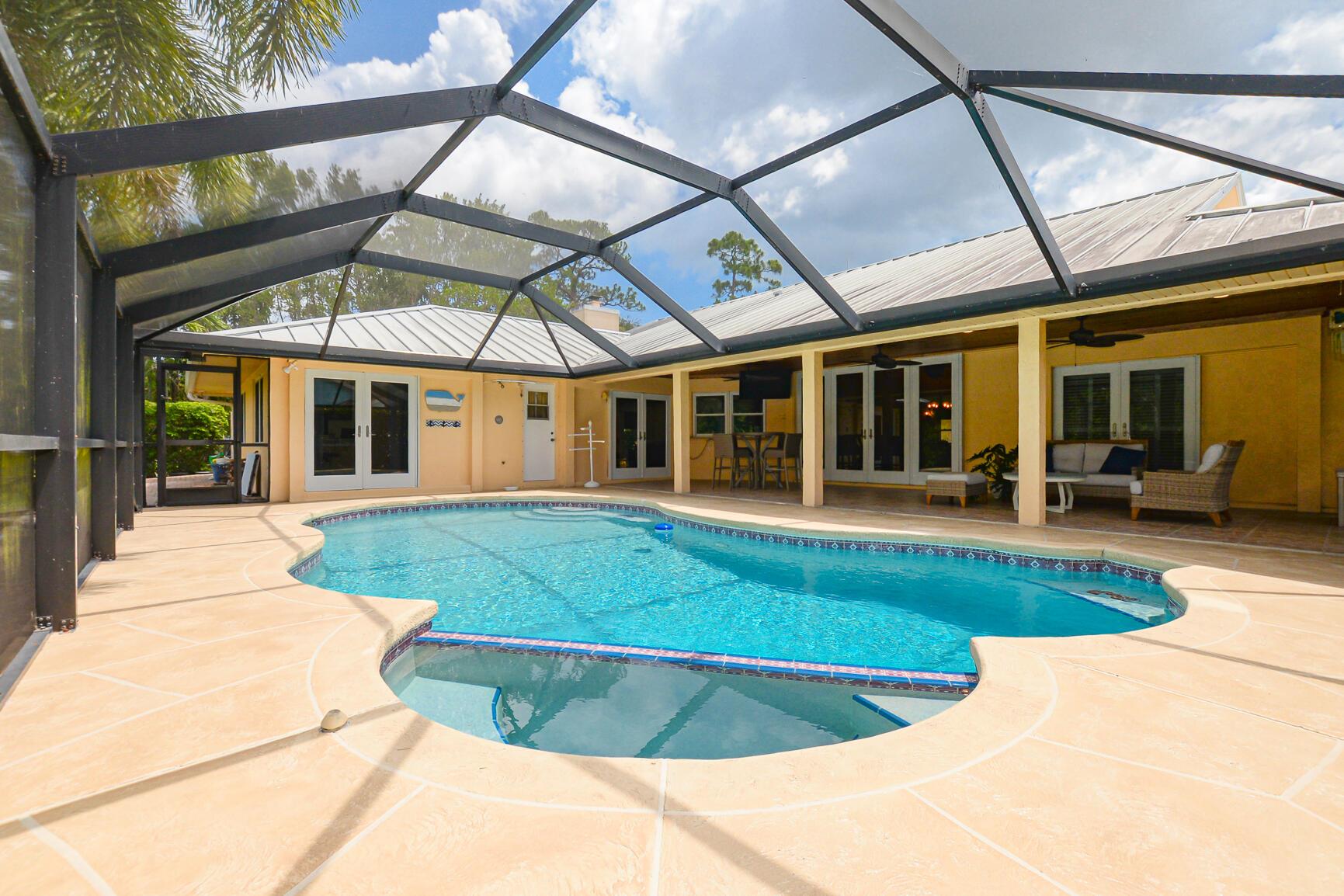 The magic begins as you drive through the gate and feel the unique calm the community provides with required 1/2 acre lots. Opening the front door of this home surprises you with high ceilings, open floor plan and views out to the heated pool, spa and lush backyard. The kitchen offers ample counter space and storage without sacrificing room to move. The attached great room with fireplace is a great focal point and leads to the other three bedrooms and bath. The third bathroom/laundry room is conveniently located off the drop-zone, running between the garage and the kitchen. Park your toys in the community lot for only $100 a year.