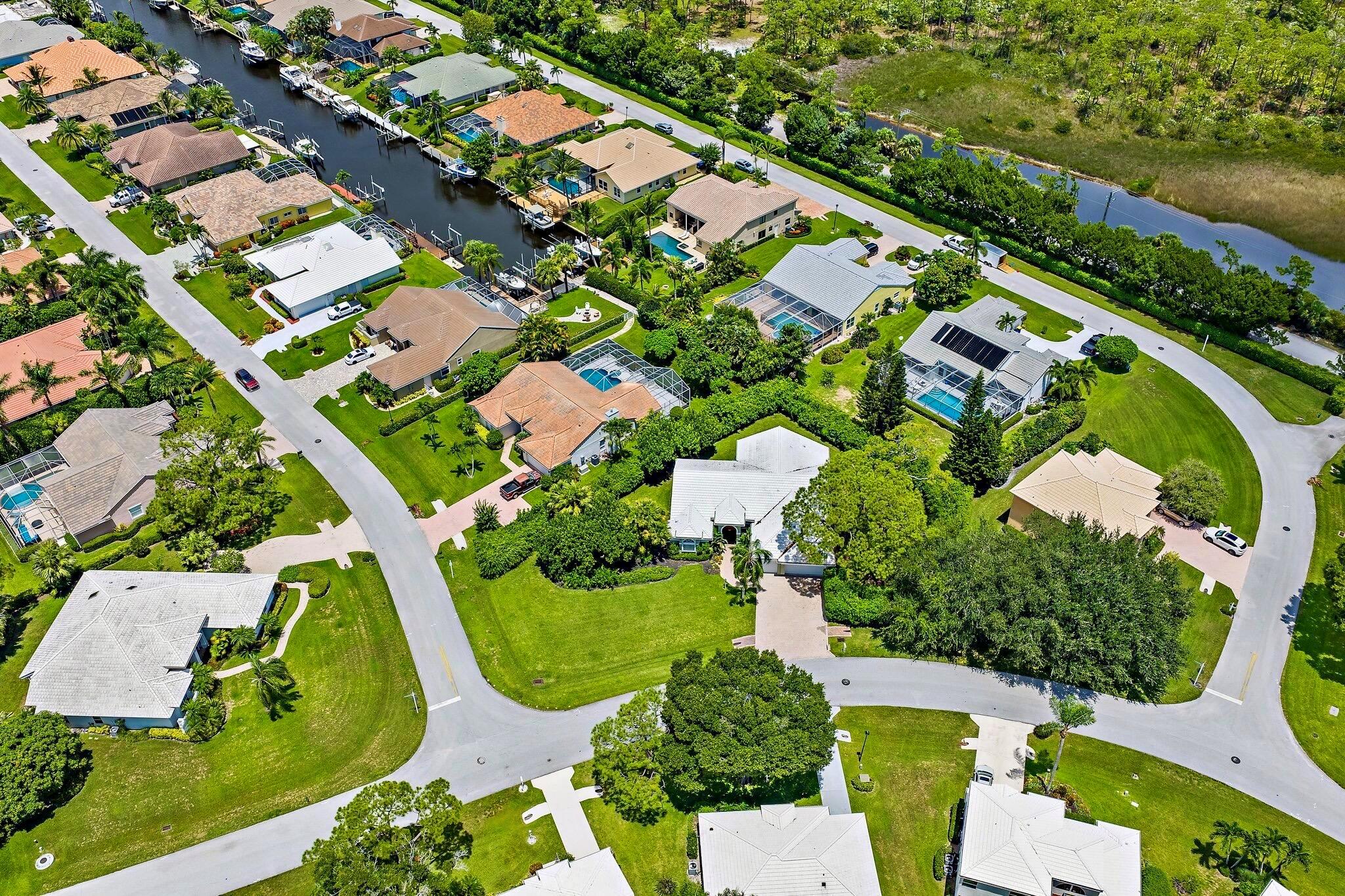 Set on a lush and private .43-acre corner lot, this move-in ready residence offers the ideal blend of comfort, elegance, and space in the highly sought-after, 24 hour manned-gated community of North Passage in Tequesta. With room to add a custom pool and surrounded by lush tropical landscaping, this is a rare opportunity to create the ultimate South Florida retreat.Owned by the original owner, this four-bedroom, three-bathroom home with a three-car garage is filled with thoughtful upgrades. Enjoy new 2024 exterior and interior paint, rich wood flooring, updated bathrooms, a 2023 tile roof, 2023 water heater, 2021 air conditioning system, and 2024 ductwork, 2024 garage door and side door, plus 2010 accordion hurricane shutters for peace of mind. The home's three-way split floor plan