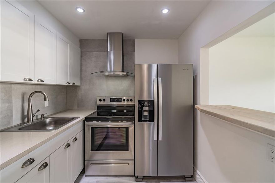 Feel at home in this spacious beautifully remodeled 1/1.5 located in the lively 55+ community of CENTURY VILLAGE EAST framed in tons of natural light with scenic lake view from your enclosed patio. This condo features laminate flooring throughout, fresh paint, renovated spa-like bathrooms, a bright white kitchen with stainless steel appliances, lots of storage space, and low HOA fees. Includes 2 brand NEW top of the line mini-splits to keep you cool and the utility bill low! Sit and enjoy a nice cup of coffee or tea in the morning as the sun rises overlooking fresh cut grass and the lake! The community features many onsite amenities including a pool, gym, & tennis courts. This condo has the perfect location with just a 5-minute drive to Quiet Waters Park, tons of shopping and fine dining!