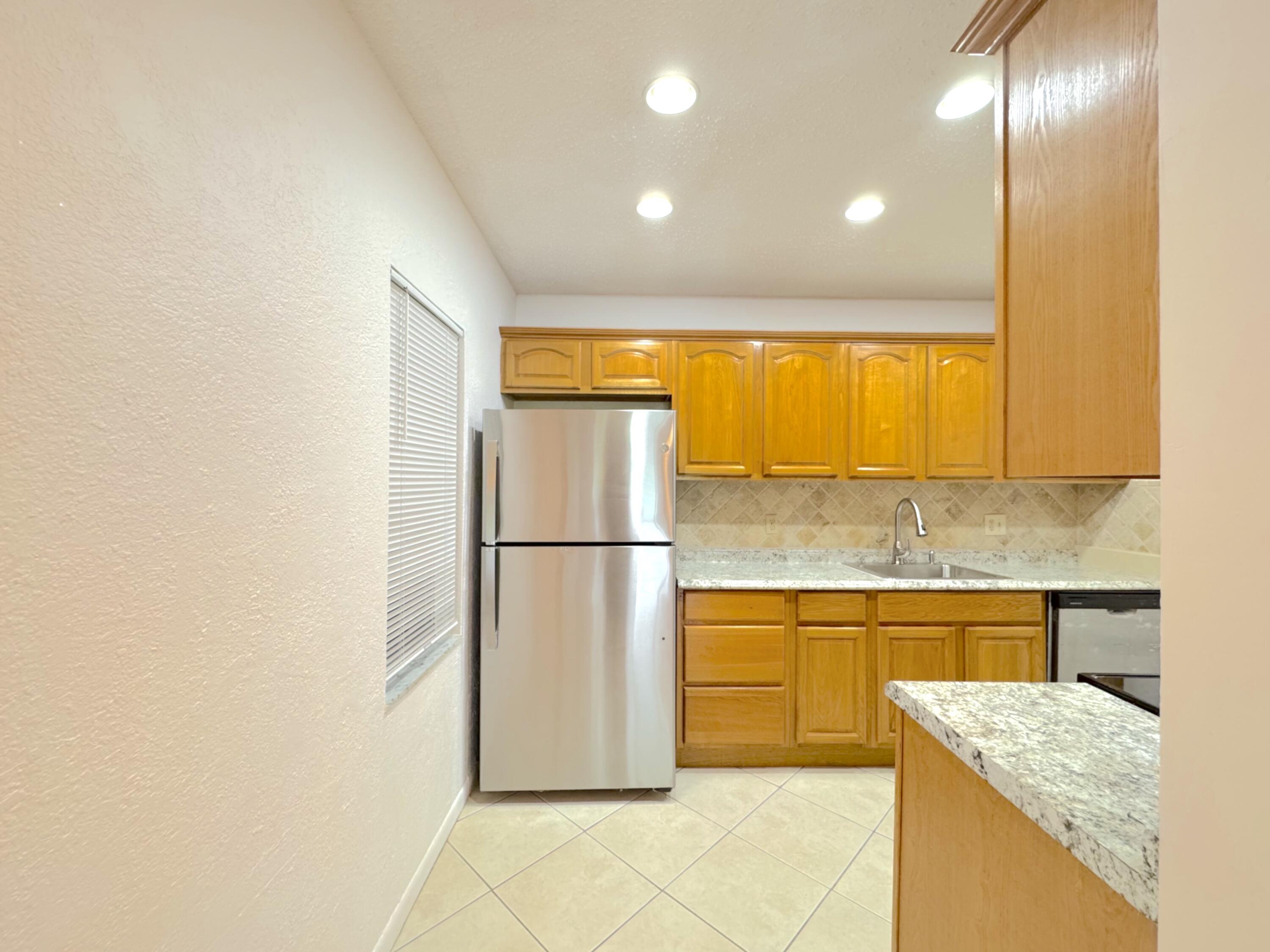 Spacious one-story villa with no neighbors to the left and a peaceful green space behind. Recently painted with updates including new ceiling fans, new refrigerator, new washer, updated microwave, and refreshed kitchen countertops. Features stylish tile floors, maple cabinets, marble backsplash, and stainless steel appliances, including a glass-top stove. Enjoy a screened patio with extra storage, full-size washer & dryer, and access to the community pool. Conveniently located near shopping, highways, downtown Boynton Beach, and Delray Beach's Atlantic Avenue!