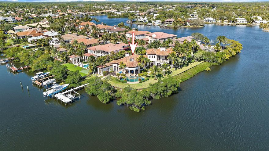 Located on an extraordinary lot with over 300 feet of waterfrontage, this estate offers ultimate privacy and breathtaking views of a protected bird sanctuary. Located in the exclusive gated community of The Islands of Jupiter, this home is perfectly positioned along the tranquil Loxahatchee River, creating an unparalleled setting for luxurious waterfront living.

This thoughtfully designed residence features 4 bedrooms, 5 1/2 bathrooms, and 6,550 of meticulously curated living space. The newer kitchen is a chef's dream, showcasing state-of-the-art cabinetry, a custom-designed 6-burner gas stove, and a strategically placed window, framing serene views of the sanctuary. With all-impact windows and doors and whole home generator, peace of mind is assured. The first floor includes three spacious bedrooms, including a VIP suite, while the primary suite occupies the entire second floor, ensuring maximum privacy and commanding riverfront views. Additional amenities include a wine room, home gym, and private elevator for seamless living.

For the car enthusiast, the property features air-conditioned garages with a two-car attached garage and a two-car detached garage. Boaters will appreciate the two boat lifts and floating dock, providing easy access to the Intracoastal Waterway and the Atlantic Ocean. The outdoor living area is a true oasis, complete with a resort-style pool, spa, multiple seating areas, and lush tropical landscaping.

Reach Island is ideally situated near world-class golf courses, fine dining, upscale shopping, and Jupiter's pristine beaches. This property is a rare opportunity to own a slice of paradise, offering a luxurious lifestyle in one of the area's most coveted waterfront locations.