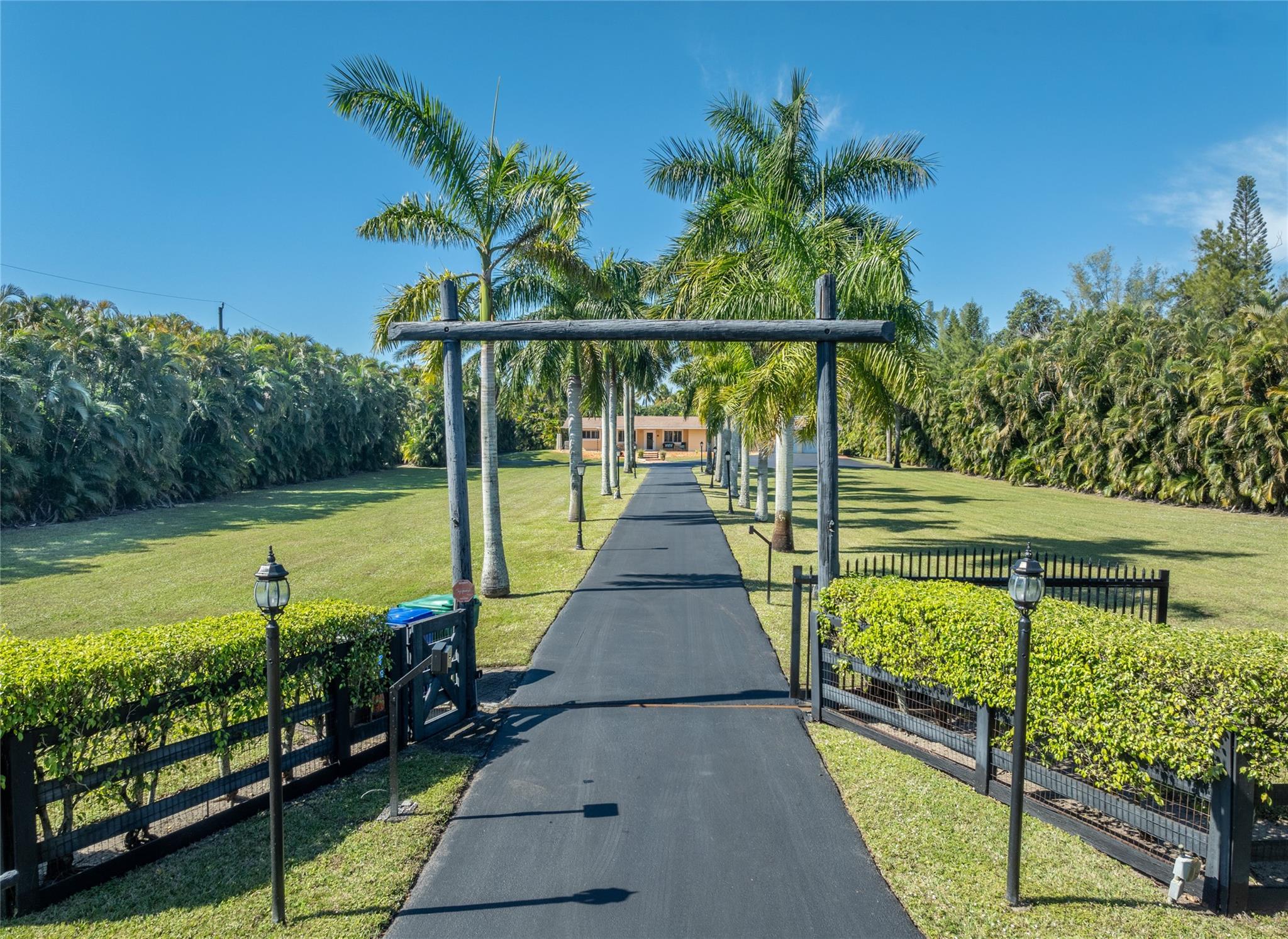 99% Vacant Home! PRICED UNDER MARKET VALUE FOR A QUICK SALE! Set on a beautifully Landscaped & Private 2.4-Acre Lot on coveted Thoroughbred Lane in SUNSHINE RANCHES! A Long, Royal Palm-lined Driveway leads to a spacious 4/4.5 Main Home, detached 1/1 Guest House (750 sq. ft.) & Furnished Office Building. This Estate offers: 4 Terraces, full Summer Kitchen, Pool, Hot Tub, equipped Gym, 60KW Generator & expansive Front & Rear Yards. Whether you're hosting guests or working from home, this Captivating Compound is ideal for Entertaining & Entrepreneurship! Impeccably maintained! Move-in Ready with incredible potential to personalize, expand, or even rebuild on one of Sunshine Ranches' most prestigious streets. This estate is priced a tad over Land Value! A rare opportunity to own a true Gem!