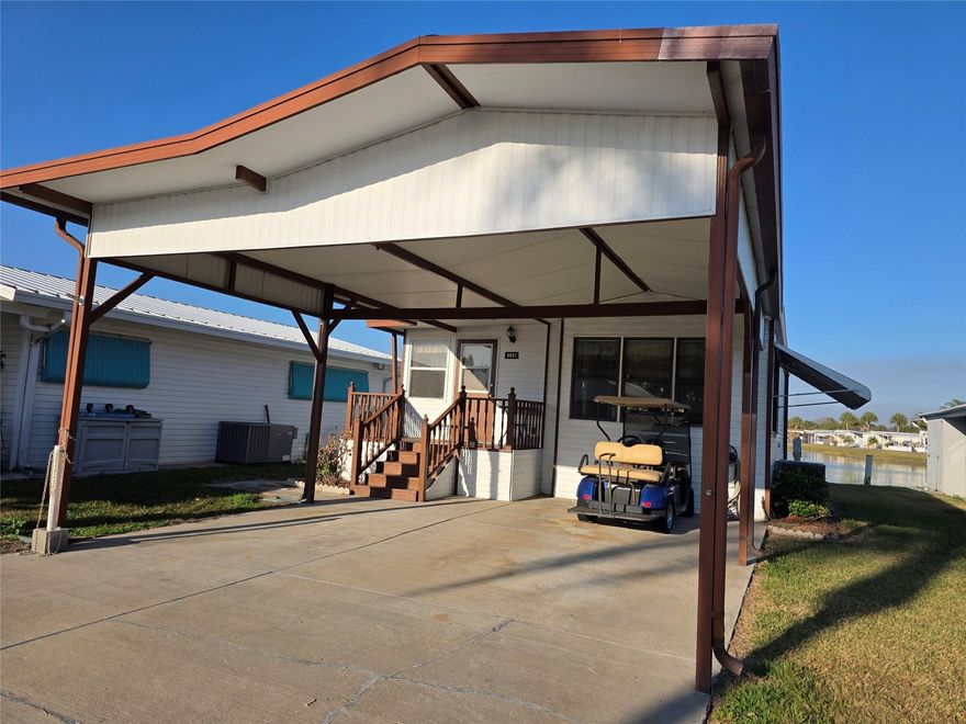 Best Buy on The Big Lake in Ancient Oaks, ideally Located on a 2 way street, is  a Vinyl sided mobile home with Metal Roof, maintained AC, hurricane shutters, full attached carport & golf cart! Two (2) bedrooms, full size washer/dryer located  inside the home, Fully furnished, Bright Open Fkoor plan with lots of living area,  Home has been consciently maintained through the years,