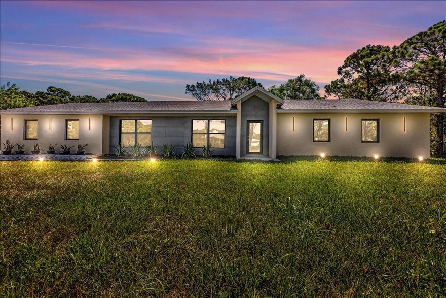 Unbelievable and unique opportunity to own 2.5 acres east of US1 in South Florida, with a completely remodeled & upgraded large, open and bright 5 bedroom 3 bathroom home w/ oversized garage. Home upgrades were all done with PERMITS. Everything is BRAND NEW, including ROOF, IMPACT windows and doors, a spacious modern chef's kitchen with European cabinets, calacatta counters/backsplash, SS appliances, slatted wood accent wall w/ electric fireplace, oversized master bedroom with his and hers closets,  maid/in-law quarters on the opposite side of the house, breakfast nook, large laundry/pantry room, and so much more.... Land is cleared around the property and the rest is ready for your imagination: ATV trails, fishing in the pond, add some horses... or garages...