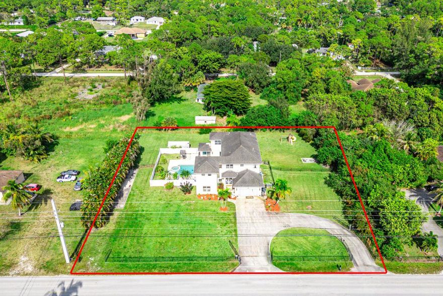 This stunning 6-bedroom, 4-bathroom estate offers approximately 4,400 square feet of living space and is perfectly designed for comfort and entertaining. Situated on over 1 acre of fully fenced land, this home features a courtyard-style heated pool and spa, ideal for gatherings and relaxation.

Located on a paved road in the heart of Loxahatchee, the property boasts a circular paved driveway and an RV pad with electric hookup. An attached efficiency provides the perfect setup for in-laws or guests.

Inside, you'll find a spacious open-concept kitchen with double refrigerators, a gas stove, and newer appliances. The expansive primary suite includes walk-in closets, while additional space allows for a home office or gym.