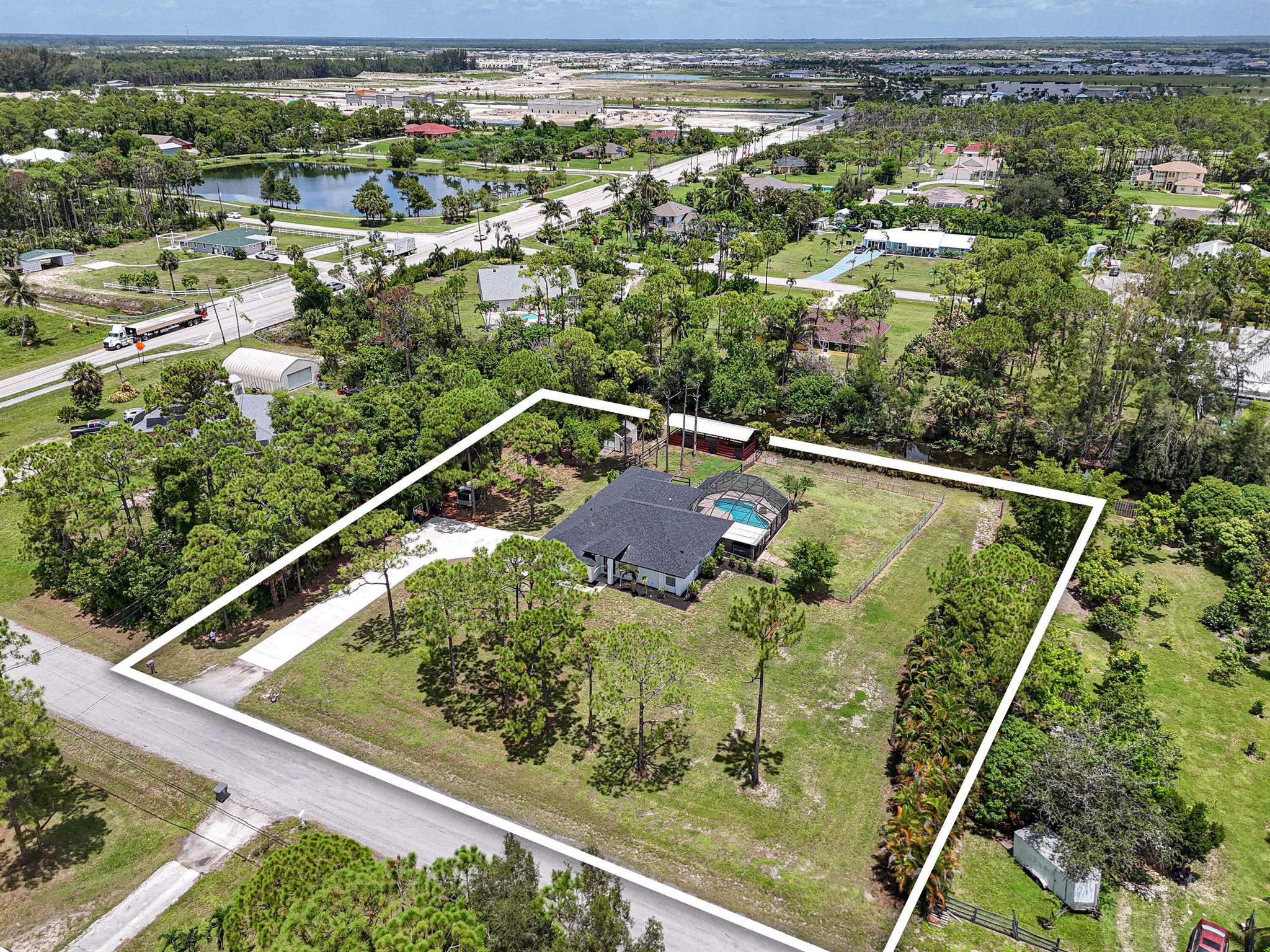 In The Acreage, location is everything -- and this 1.29 -acre equestrian property with 3 horse stalls is a rare find near the main road, just steps from Hamlin Horse Park and riding trails. Designed for both riders and relaxation, the CBS 4BD/2BA home features vaulted ceilings, an open concept layout, brand-new roof, new HVAC, upgraded water system, striking new exterior, and a screened-in pool with over 1,600 SF of entertaining space, solar-ready heating, and lifetime structural warranty. Also features a cabana bath, plantation shutters, hurricane-rated garage, generator-ready hookup, solar water heater, poured concrete driveway, and plenty of space for trailers, boats, and toys. Country-style living with city-like convenience -- all minutes from shopping, dining, and the beach.