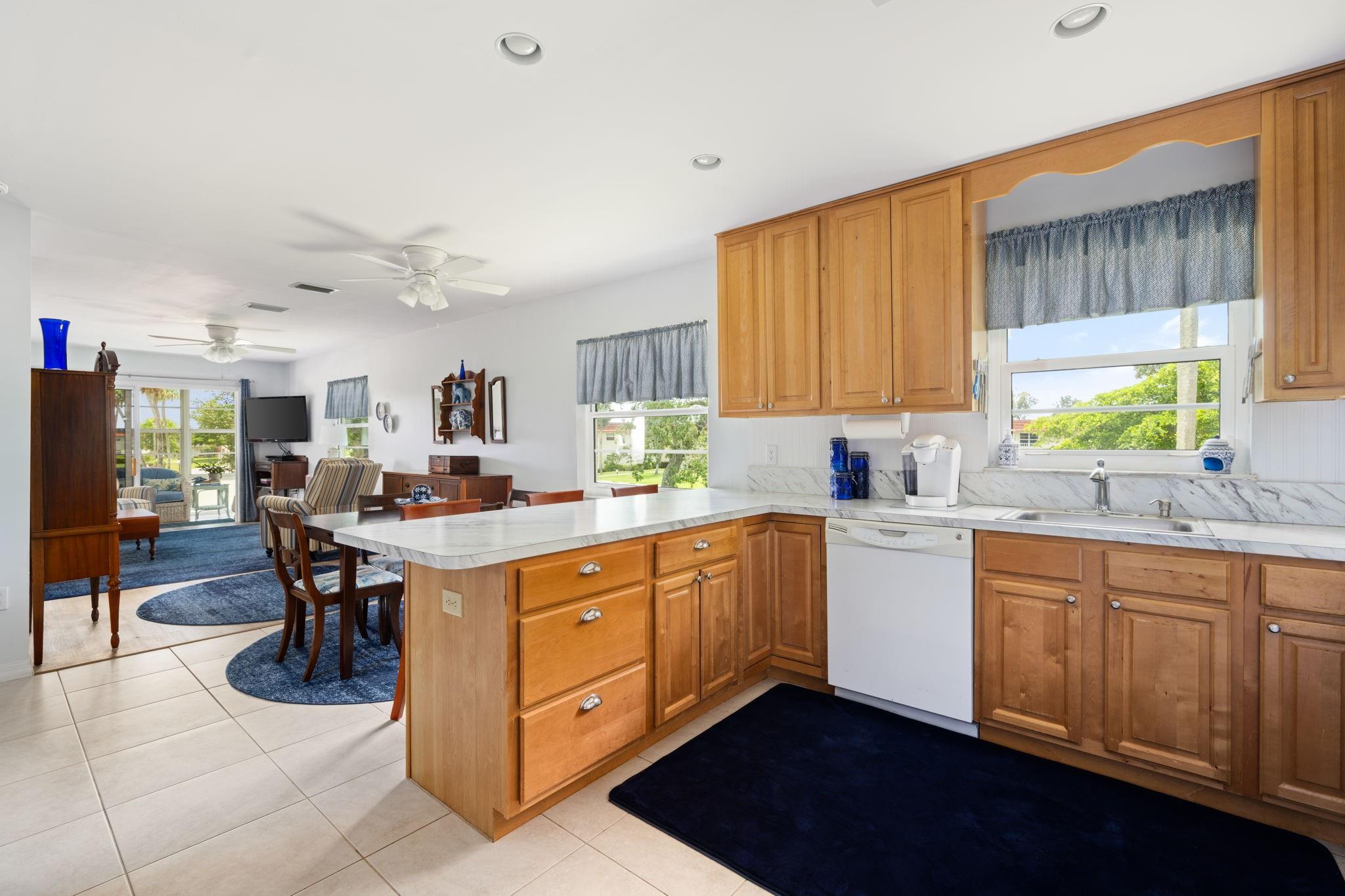 OPEN SUNDAY 27th from noon to 2:00! Discover this stunning home featuring a convenient snack counter, creating an oasis filled with updates that enhance your lifestyle. Enjoy captivating views and lush greenery, along with impact windows for added peace of mind. Benefit from top-notch recreational facilities, pools, a fitness center, tennis, and a vibrant social calendar in a lively 55-plus community, minutes from beaches, dining, shopping, and golf. The sought-after B plan showcases elegant tile & laminate floors, a newer air conditioning unit, and an in-unit washer. With recent upgrades to the building's infrastructure and the seller covering assessments, this home is not just a residence but an investment, allowing rentals in the first year. Don’t miss out on this exceptional property!