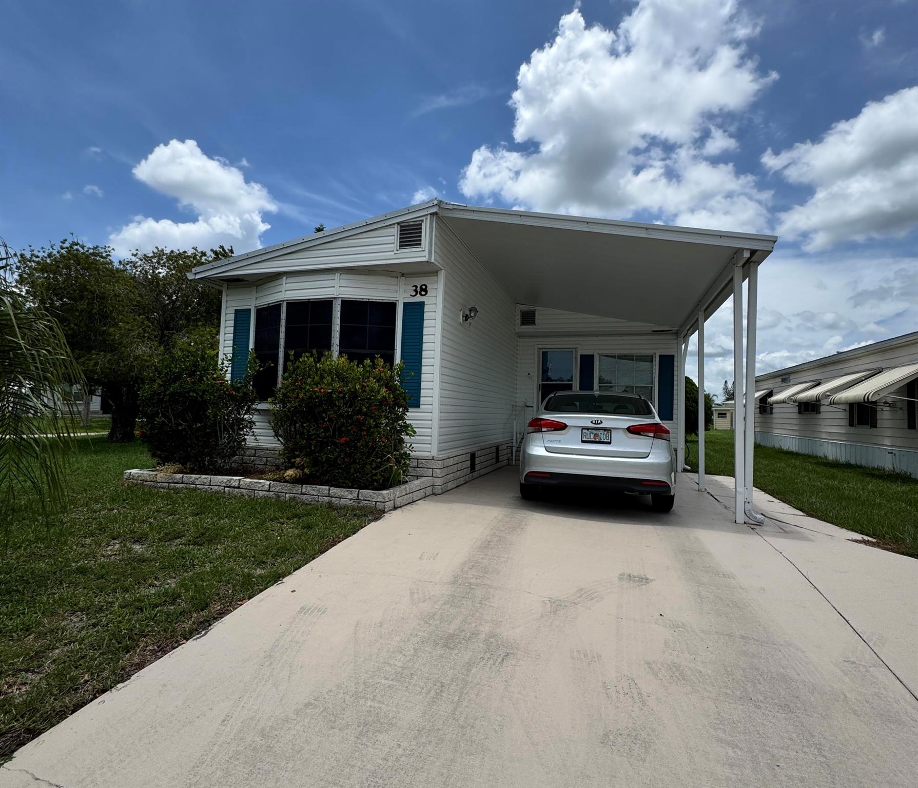 Well maintained 2 bedroom 2 bath home in the 55+ community of Spanish Lakes Country Club Village. Home is very close to entrance of the park and the community center. Home is a split floor plan. Home has a patio off family room as well as screened in patio off rear of home. Home has carpet and laminate flooring. Metal roof 2022, A/C 2019. New gutters 2024, New waterline installed in 2024, New faucet 2025, Driveway has been painted in 2025, Exterior of home painted in 2023. Home has a shed and laundry room in rear of home. Lawn care and trash removal included in lot rent. 2 pools, tennis, pickleball, bocceball, shuffle board. club house and much more. SELLER IS MOTIVATED! Priced to sell!