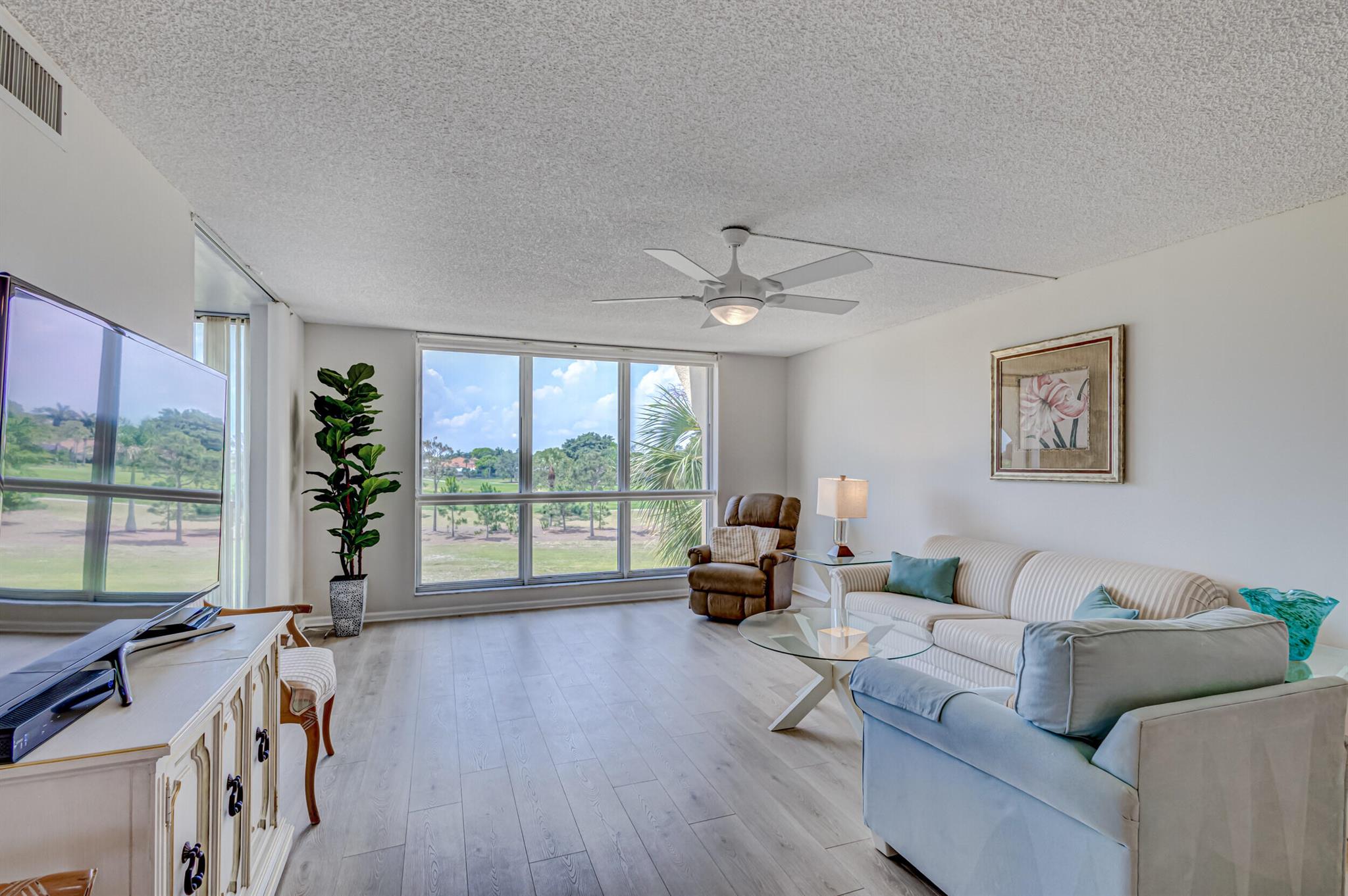 Gorgeous view of the 17th & 18th fairways & lakes in Ballenisles from every room! Uniquely designed to have more air conditioned space with glass enclosed balcony. Sliding doors allow air flow in the cooler months. Split floor plan features 2 master suites with updated dressing areas. Primary bedroom has two (2) huge walk in closets! Wide plank vinyl flooring in main living areas and bedrooms. Full sized washer & dryer inside the unit. Includes deeded covered carport space plus two (2) additional storage areas. Pet friendly neighborhood allows 2 pets under 25 lbs. Three (3) pools, tennis court, clubhouse. Milestone inspections complete. Major project assessments and work completed! Well managed and funded condominium complex catering to 55+ generation. 1 mile to either I-95 or turnpike.
