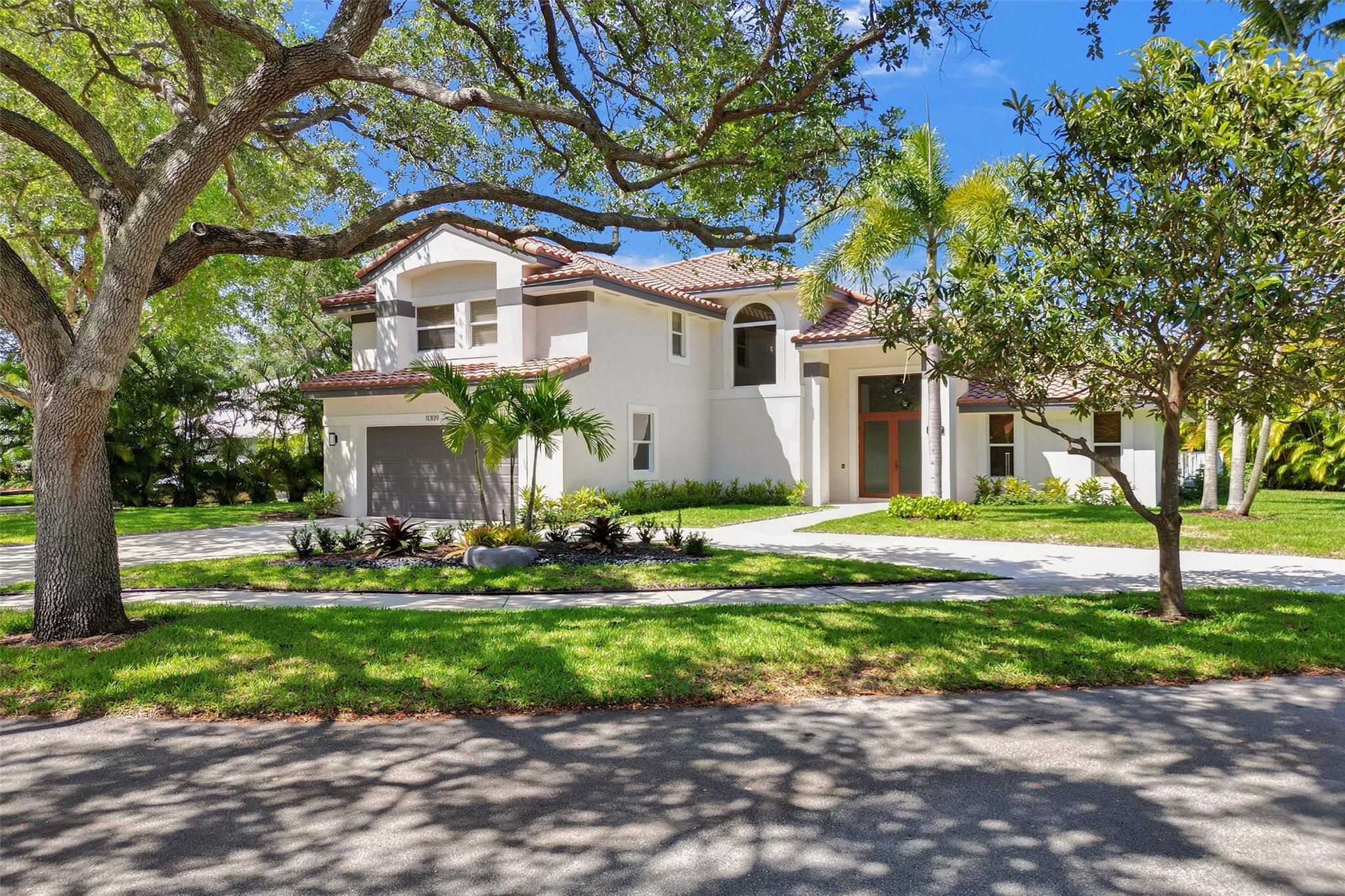 Discover timeless elegance and South Florida charm in this exquisite 5-bedroom, 3.5-bath pool home in the highly sought-after East Landing section of Rock Creek, Cooper City, with only 44 homes!. Located on a prime corner lot with lush landscaping and a stately circular driveway, this residence offers over 3,500 square feet of stylish, well-maintained living space—perfect for family life and entertaining. Step through the double-door entry, and you’re greeted with vaulted ceilings, oversized windows, and abundant natural light that highlights the home’s inviting and expansive layout. Key features: New A/C, new kitchen, new stairway, garage built-ins, interior and exterior paint, Barrel tile roof (2017), fresh landscaping, wood floors, bedroom/bath downstairs, and impact windows/doors.