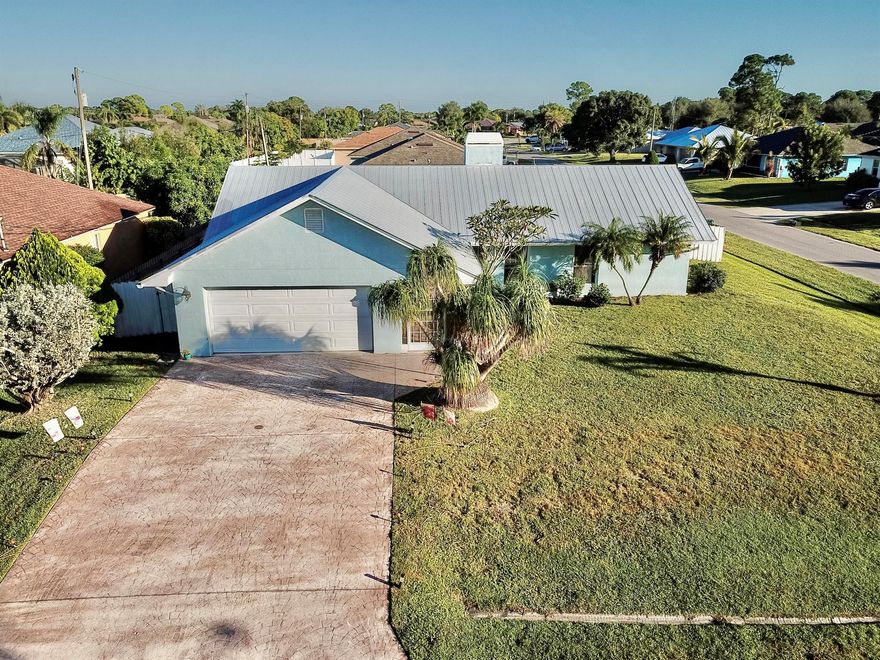 Charming 3 Bedroom, 2 Bath Home on a Corner Lot - No HOA! Welcome home to this beautifully maintained 3-bedroom, 2-bath, 2-car garage residence located on a quiet street in Port St. Lucie. Featuring a metal roof (2017), newer A/C, and a recently installed fence, this home is move-in ready and offers lasting peace of mind. Inside, you'll love the inviting living area with a cozy fireplace, perfect for relaxing evenings. The spacious kitchen includes a convenient pass-through to the enclosed porch, ideal for entertaining or enjoying a quiet morning coffee. The 1/4-acre corner lot provides plenty of outdoor space for gardening, pets, or family gatherings. With no HOA, you'll have the freedom to park your boat or RV and make the property your own. Conveniently located near shopping, dining,