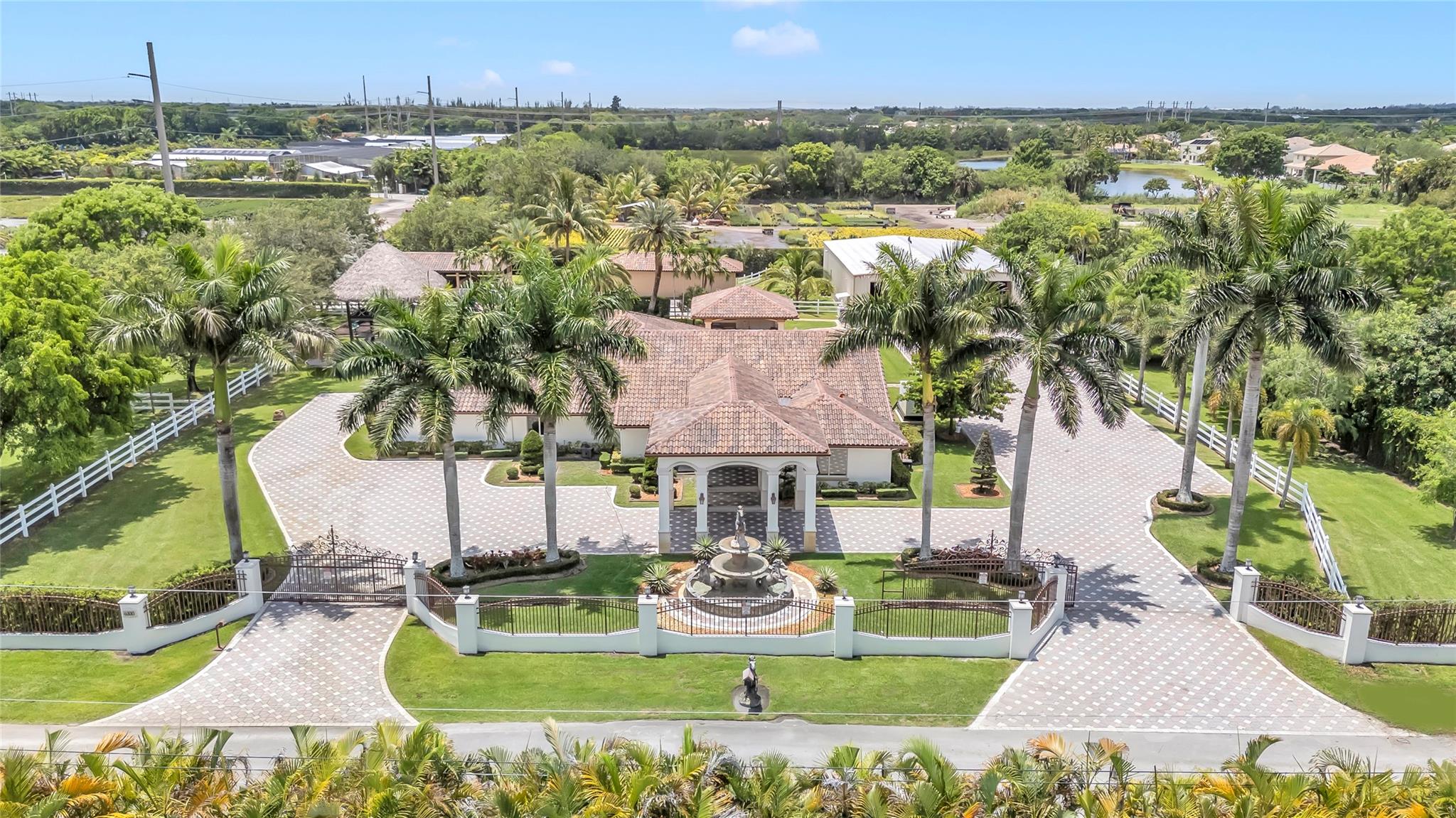 Welcome to this ultra-luxury estate in prestigious Southwest Ranches, set on 2.03 meticulously maintained acres. Fully renovated with no expense spared, this exceptional property is a true masterpiece. The estate includes 8 horse stables & a separate 4,000 sqft garage featuring a private upstairs office with A/C, ideal for conversion into a guest house and another 1,000 sqft garage/storage area. The main residence spans 4,000 sq ft under air and showcases 5 bedrooms, 4 bathrooms, impact windows, a redesigned private gated driveway, and a laundry/utility/mudroom for added functionality. Step outside to your private resort-style oasis, complete with a large pool, Brazilian teak wood ceilings, a summer kitchen, a pool house, and a stunning two-story tiki hut with electric and lighting.