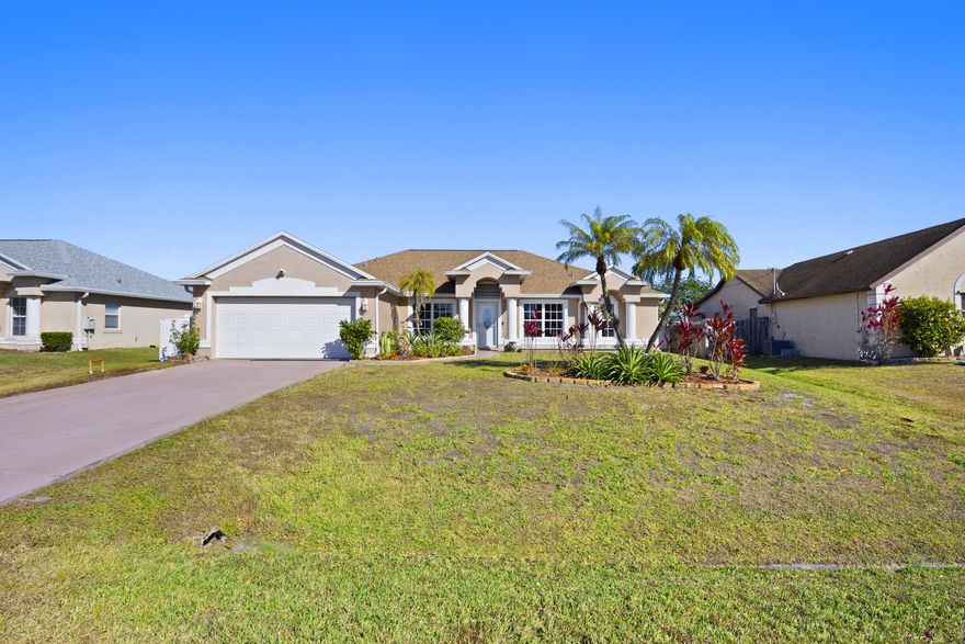 Located in the desirable South Bend neighborhood of Port St. Lucie, just minutes from the C24 canal boat ramp with ocean access, this spacious 4-bedroom, 3-bath pool home offers an open layout, vaulted ceilings, skylights, and a functional split-bedroom design. Enjoy a private screened pool and patio with cabana bath, perfect for entertaining, plus a tiki bar and outdoor TV setup. The primary suite features a soaking tub, separate shower, and walk-in closet. Updates include a 2021 roof, 2021 A/C, and smart home features. Zoned sprinkler system on well. No HOA allows room for boat or RV parking. Close to shopping, dining, parks, and major roadways.