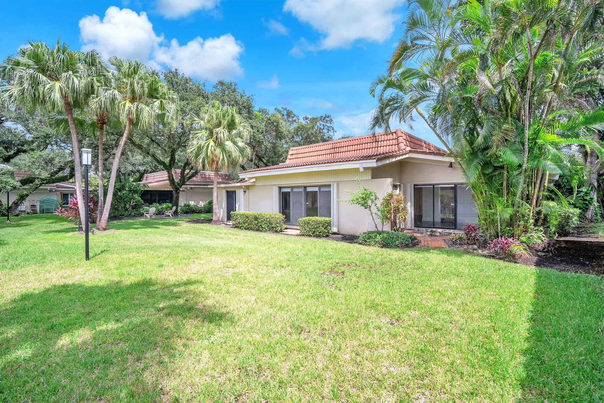 Discover this charming 2-bed, 2-bath villa, with an additional enclosed patio/bonus room, can be made a third bedroom or office. Perfectly nestled between lush, tree-lined views and a serene golf course. Ideal for downsizing or starter home. This ground-level home offers bright natural light, vaulted ceilings, a carport with two spaces, and an inviting eat-in kitchen. The formal dining space is perfect for hosting, while the garden views provide a peaceful retreat. Enjoy your community heated pool and patio. Located in the sought-after Hollywood community, you're just minutes from houses of worship, parks, playgrounds, and only 6 miles from the beach. Pet-friendly and newly painted, this turn-key home is move-in ready—don’t miss out!