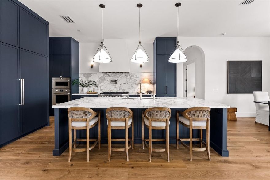 Step into a residence where every detail has been thoughtfully curated to balance modern functionality with timeless design. At its heart lies a bespoke kitchen, enveloped in Italian Statuario Belgia marble with a striking three-foot backsplash, complemented by a Sub-Zero/Wolf appliance suite, handcrafted custom cabinetry, and European white oak hardwood floors that flow seamlessly throughout the home. The primary suite offers a serene retreat, complete with travertine floors, custom dolomite vanities, a walk-in rainfall shower, and a luxury soaking tub reminiscent of a spa experience. Additionally, an expansive den offers a light-filled space ideal for a home office or study. Outside, enjoy panoramic lake views, a fully fenced yard, and the privacy of a generous one-third-acre homesite.