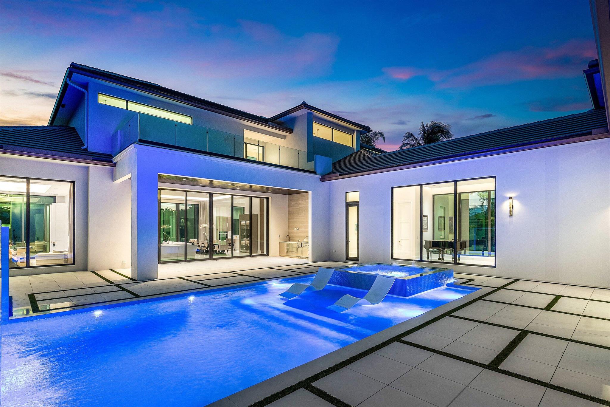 An architectural gem newly constructed in 2024, this custom-built courtyard home showcases expanses of glass that seamlessly integrate the indoor and outdoor environments. 12' glass windows and doors which frame eastern and western views illuminate the home with natural light. Modern design elements, coupled with hardscape accents in geometric form, create a stunning effect.The interiors have a refined, sophisticated aesthetic with soft tones and exquisite finishes. The home offers 5714 living sq ft, 4 ensuite bedrooms, 5.5 baths, office, entertainment room (which can be converted to a 5th bedroom with a full bath), temperature-controlled 200 bottle wine room, glass-railed floating staircase, music gallery, and 3 air-conditioned garage spaces (constructed to accommodate 6 cars using