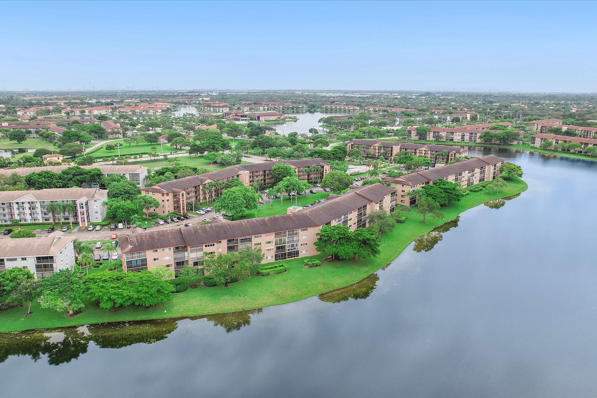 Tranquil 55+ waterfront condo offering an open, spacious layout with tile floors throughout and a bright white kitchen. The primary suite features an ensuite bath, large walk-in closet, and balcony access shared with the living room, overlooking a serene lake. Resort-style amenities include indoor and outdoor pools, clubhouse, golf, pickleball, theaters, restaurants, courtesy transportation, health clubs, marketplace, and more. Recent updates include A/C (2020), newer washer and dryer, ceiling fans, and vanities. Accordion shutters provide full storm protection. One assigned parking space. Ideal as a primary residence or easy getaway. Mortgage savings may be available for buyers of this listing.