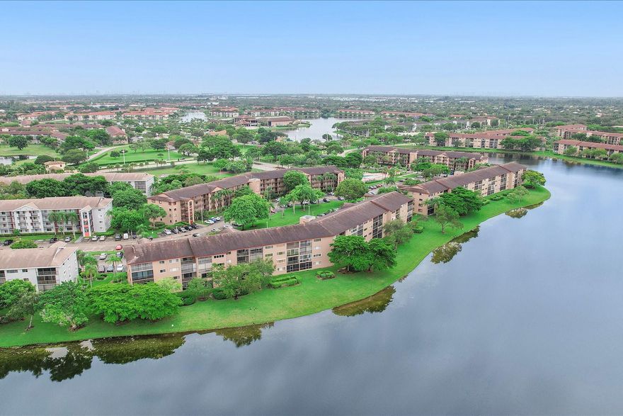 Tranquil 55+ waterfront condo offering an open, spacious layout with tile floors throughout and a bright white kitchen. The primary suite features an ensuite bath, large walk-in closet, and balcony access shared with the living room, overlooking a serene lake. Resort-style amenities include indoor and outdoor pools, clubhouse, golf, pickleball, theaters, restaurants, courtesy transportation, health clubs, marketplace, and more. Recent updates include A/C (2020), newer washer and dryer, ceiling fans, and vanities. Accordion shutters provide full storm protection. One assigned parking space. Ideal as a primary residence or easy getaway. Mortgage savings may be available for buyers of this listing.