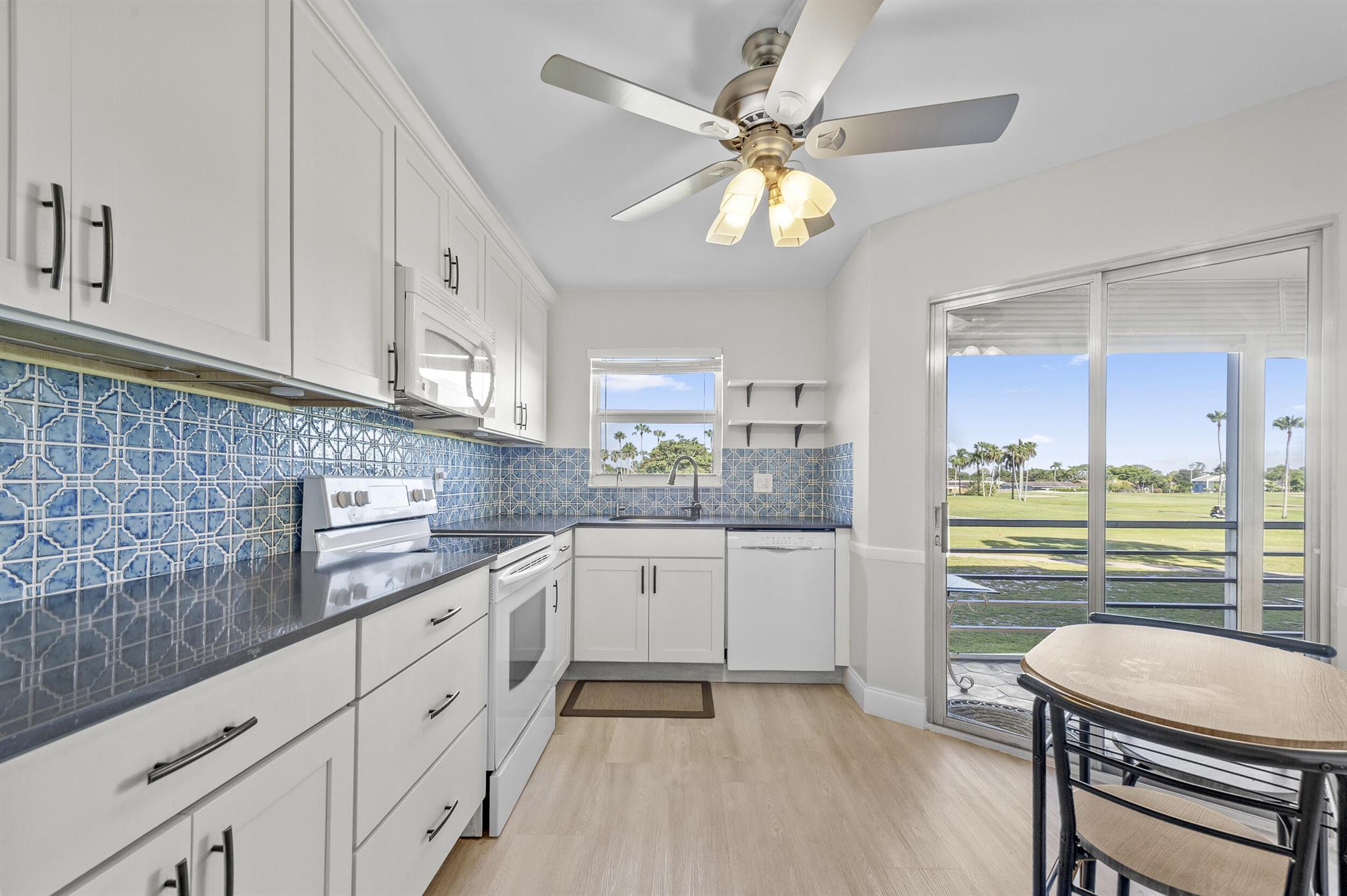 Welcome to this beautifully upgraded true corner unit in the highly sought-after 55+ community of Poinciana Place in Lake Worth! This spacious 2-bedroom, 2-bath condo is filled with natural light from extra windows and offers enhanced privacy with its end-unit location. Enjoy the Florida lifestyle from your oversized screened-in patio, where you'll be treated to expansive, panoramic views of the manicured golf course -- the perfect spot to relax with morning coffee or unwind at sunset. The patio also features roll-down hurricane shutters for added protection and peace of mind. Step inside to a bright, open layout featuring new modern ceiling fans and lighting fixtures throughout, along with tasteful new window treatments that complement the home's clean, updated look.