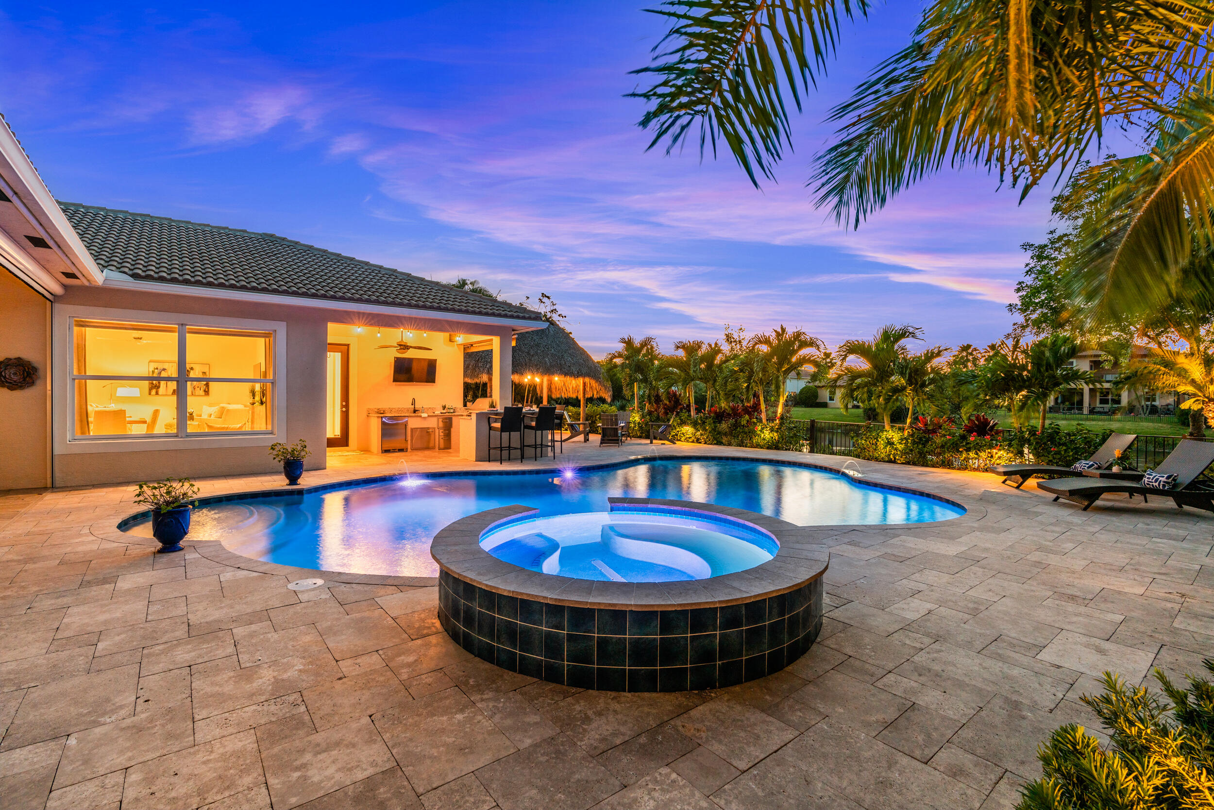 Welcome to Jupiter's most sought after gated community Rialto, located in the heart of sunny Jupiter FL. This tastefully appointed Briarbrooke model is situated on a gorgeous lakefront .30 acre lot with a stunning free form resort style pool and spa, tiki hut, electric screens on the lanai and Summer kitchen/bar. The home features 5 spacious bedrooms 4 full baths, 3 car garage and a space designed to bring homeowners renewed energy, relaxation, and luxury. Built in 2014 this popular one story home is sure to impress the minute you enter the double front doors. Freshly painted inside the bright open floor plan is complimented by clean lines and neutral colors. 24'' porcelain tile flooring in main living areas and wood flooring in bedrooms add warmth to each room