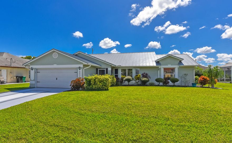 Superbly maintained 3/2/2 CBS pool home! Standing seam metal roof installed 2024. AC is 2020. Open floor  plan with vaulted ceiling's. Beautiful stone feature wall in living area. Open & bright kitchen has custom cabinets with pull outs, granite counters, stainless steel appliances (new dishwasher) & pass thru to the screened pool enclosure. Primary bedroom with en suite, dual sinks, soaking tub and separate shower, walk-in closets, tray ceiling & sliders to the lanai. Guest bedrooms have large closets & share cabana bath.  Back yard features gunite pool, screen enclosure, shed wired for power, mature landscaping. Separate well used for a  4 zone irrigation. Painted driveway, shutters, garage cabinets round out this must see home - priced smart and includes a one year home warranty!