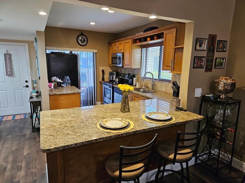 PRICE ADJUSTMENT !! This stunning end-unit villa offers privacy, security, and luxury in a 24/7 manned guard-gated community. Enjoy a beautifully updated interior with granite countertops, stainless steel appliances, solid wood cabinets with soft closures, LED lighting, and a kitchen sensor faucet. The home features a Murphy bed, shutters, a boarded attic floor, and two fenced-in patio areas and Full-sized washer & dryer in-unit. $524/M Maintenance includes Insurance on Unit, cable and Internet, 24/7 Security, common areas, resort-style amenities, including a clubhouse, fitness center, two pools, kiddie pool, hot tub, saunas, billiards, jogging trails, playground, tennis, pickleball, and basketball courts. Experience stylish living in this exceptional villa! Security cameras do not convey