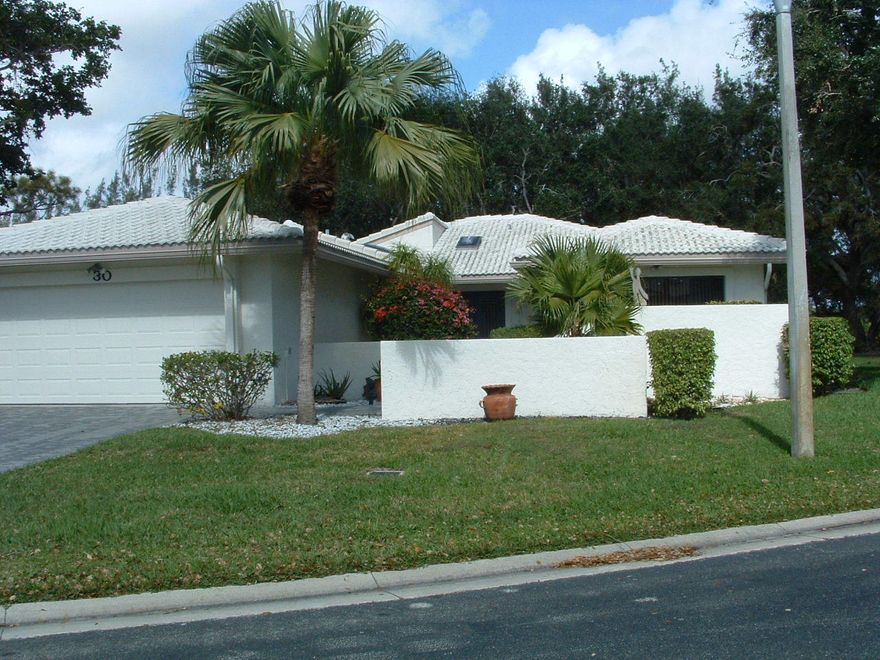 You have arrived at 30 Hampshire Lane. Well maintained and classically designed,this home was built for maximum privacy. With green space on the right and set back for privacy from your neighbor on the left, you can enjoy cocktails watching the sunset on the lanai while overlooking the 15th hole on the North Course. Entering the tastefully decorated home, your eye is drawn to the vaulted, beamed ceiling great room to the glass wall overlooking the golf course and lake. Skylites strategically placed throughout bring in sunlite to brighten the space.
Love to entertain family and friends? The expansive great room easily accommodates 40+ guests with its open design. Serve cocktails at the bar, then move to the dining area and finally relax in one of the two large conversation spaces. There ar 2  generous bedrooms, each with ensuite bath. The master has a jetted  tub, separate shower and his/her vanity.
There is a large walk-in closet for her and spacious closet for him. Guest bedroom has double wide closet and tub/shower in the bath.
A bonus room off the kitchen presently serves as a den but can easily be a third bedroom. Next to that is an office/den with an exit to an outdoor grilling area .A powder room and 2 large closets are conveniently located off the foyer. A two car garage leads to the kitchen with a pantry closet and laundry room.
This inviting home has great bones. Put your personal touches to it and enjoy it for years to come