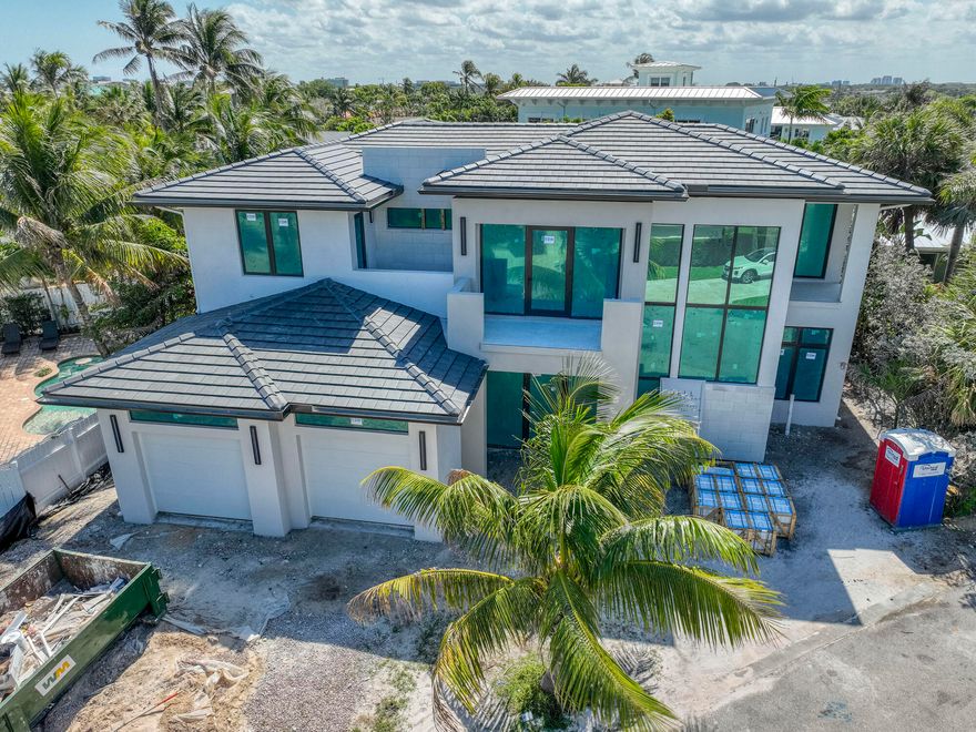 Steps to the beach. Nestled within the highly sought-after enclave of Juno Beach lies this exquisite example of modern new construction. This residence boasts an inviting open-concept design, adorned with luxurious wood flooring throughout and high-end fixtures, promising a lifestyle of both elegance and comfort. With 5 bedrooms, each accompanied by its own en-suite bathroom, this home offers unparalleled convenience and privacy. The upstairs living area has a loft and the rooms have access to three terraces, perfect for soaking in the Florida sun or enjoying evening breezes. Elevator shaft has been built giving you the option of installing. Downstairs, one of the bedrooms presents a versatile space, ideal for use as an office or guest accommodation. The heart of this home is its meticulously crafted kitchen, featuring custom cabinets and an oversized quartz waterfall island, perfect for both culinary pursuits and casual dining. Seamlessly connected to the kitchen is the open living area, boasting a built-in fireplace and offering panoramic views of the outdoor living space through impressive 10-foot sliders.
Step outside and discover an entertainer's paradise, where you can host gatherings with ease in the summer kitchen, or unwind by the poolside oasis complete with a built-in spa. Enclosed within a fenced backyard, this outdoor retreat ensures the utmost privacy, allowing you to fully embrace the serene surroundings.