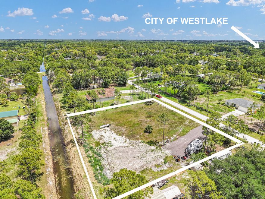 Build the home of your dreams on this exceptional 1.3-acre cleared lot in desirable Loxahatchee, Palm Beach County FL!  This high and dry parcel is fully cleared and ready for development, offering a true blank canvas for your custom estate or equestrian retreat. The property is already improved with electric service connected on-site, a well for water, a water softening system, an extra wide asphalt millings driveway, an EV charger, and an RV water connection saving you significant time and upfront development costs. Additionally, approximately 30 loads of fill have been brought in, providing added elevation and a solid foundation for future construction. Enjoy the freedom of no HOA, allowing you to design and use your property without restrictive rules or fees. With ample space for a main residence, guest house, pool, or additional structures, this oversized lot offers flexibility and long-term value. Bring your horses, RV's, boats, and toys! Backs up to a canal for easy irrigation. Conveniently located near the City of Westlake and the new Avenir master planned community, close to all shopping, dining, and major roadways while still maintaining the privacy and tranquility Loxahatchee is known for. Currently zoned for excellent Westlake schools, and within a half hour drive to downtown West Palm Beach. Whether you're ready to build now or invest for the future, this is a rare opportunity to own a build-ready acreage property in one of the most rapidly-growing counties in South Florida.