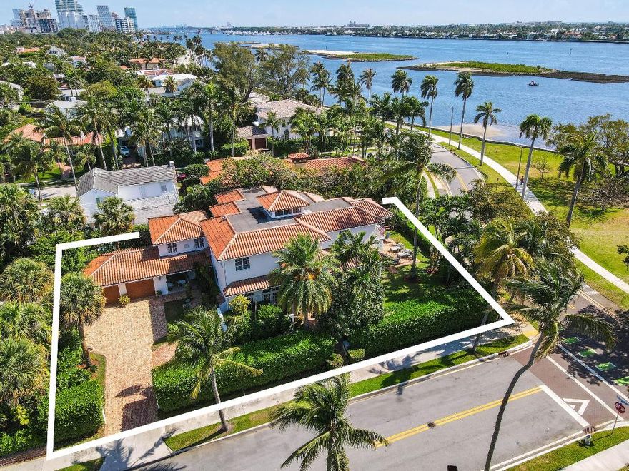 Elegant Waterfront Living in Historic El Cid. Experience timeless sophistication and breathtaking Intracoastal views from this newly renovated Mediterranean-style estate, ideally positioned on an elevated corner lot in one of West Palm Beach's most coveted neighborhoods. Built in 2002 and newly updated, this grand residence captures the essence of luxury coastal living. Set on over 10,000 square feet of exquisitely landscaped grounds, the 5-bedroom, 5-bath home showcases an open-concept layout with soaring ceilings and impact glass, framing stunning water views from the kitchen, living room, and primary suite. Designed for effortless indoor-outdoor living, the property features a heated pool, waterfall spa, and multiple covered loggias surrounded by lush tropical landscaping, perfect for entertaining or quiet relaxation. Additional highlights include a separate two-story guest house, air-conditioned two-car garage, new HVAC systems, whole-house generator, and fresh exterior paint. Nestled in the historic El Cid neighborhood, this elegant estate offers serenity and sophistication, just minutes from the beaches, fine dining, and world-class shopping of Palm Beach Island, including the iconic Worth Avenue. A rare opportunity to own a private, waterfront retreat in one of South Florida's premier locations.