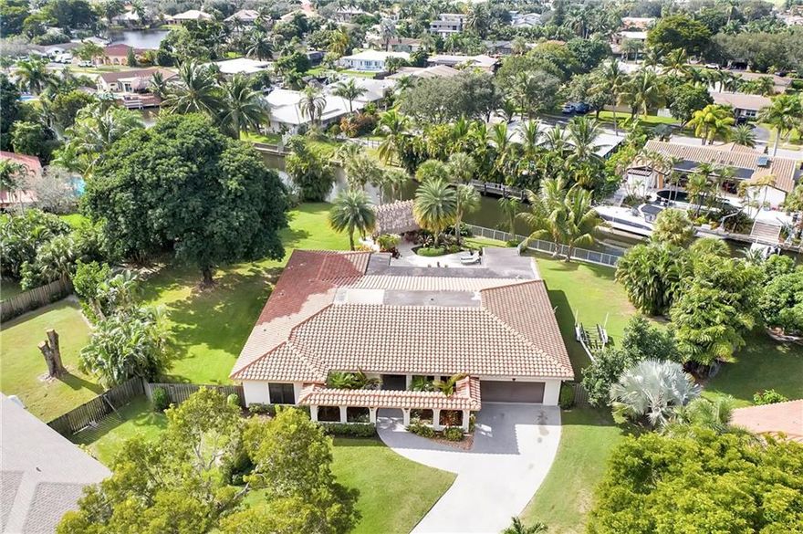 Spectacular ocean access waterfront pool home in Plantation! Like living in your own private park oasis. Home features over 1/2 acre of ocean access waterfront lot, pool w/French pattern marble paver deck, built-in grill, covered patio area as well as custom chickee hut w/built-in wet bar and TV capability. Interior features; tranquil custom kitchen w/exposed beams & vaulted tongue & groove ceiling, solid surface counter tops, stainless appliances and custom cabinets. Home features 10 foot ceilings, INSULATED IMPACT windows for storm protection and energy savings. Living room, atrium in center living area, dining room, family room, large laundry room, split bedroom plan. 3 bedrooms 3 full bathrooms and a large office, could be 4th bedroom. Light and bright home, cul-de-sac lot. EXCLUSIONS. Home can be 4 bedroom. 4th is currently set up as large office with no closet. Ocean access home with significant water frontage, large dock complete with boat lift. Huge yard with plenty of room for family and entertaining. Chickee Hut has a built in wet bar area. Patio has built-in grill. Family room has a large full cabana bath that serves the house as well as the pool area. Back yard and side yard areas are very large with lots of open space. Very large waterfront footage. This is an extremely well maintained and manicured home. A pleasure to show.Roof replaced 2014. Garage door and windows approximately 2016. Electric Panel & grounding for boat lift 2016.Dining room "PINEAPPLE CHANDELIER" and Family room "NAUTICAL CEILING FAN" are excluded from the sale and are being replaced. NOTE: ATRIUM GLASS INTERIOR OF HOME IS NON-IMPACT