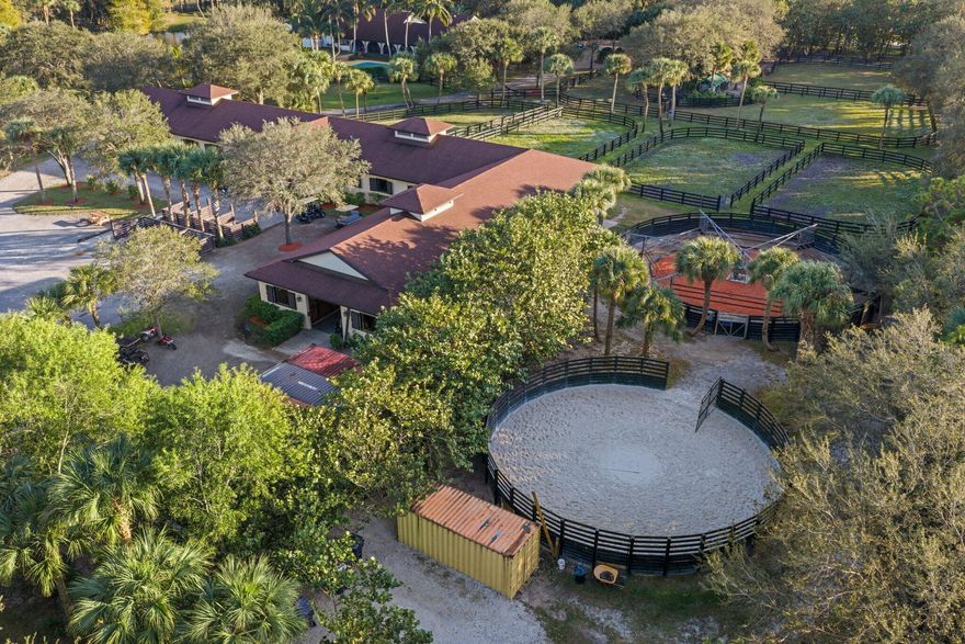 Set on 10 pristine acres, this professionally designed, championship-caliber equestrian estate delivers an exceptional blend of luxury, functionality, and top-tier performance. Purpose-built for serious equestrians, the property features a meticulously planned 30-stall barn, with each 12' x 12' stall outfitted with fans, windows, automatic water, spigots, hurricane shutters, and an integrated fly spray system--ensuring optimal comfort, safety, and efficiency year-round. The barn is thoughtfully designed with a stunning center aisle finished in Equitan rubber flooring and offers outstanding amenities, including two full bathrooms with showers, ten dedicated tack-up areas, three separate tack rooms, and three feed rooms equipped with washers and dryers.