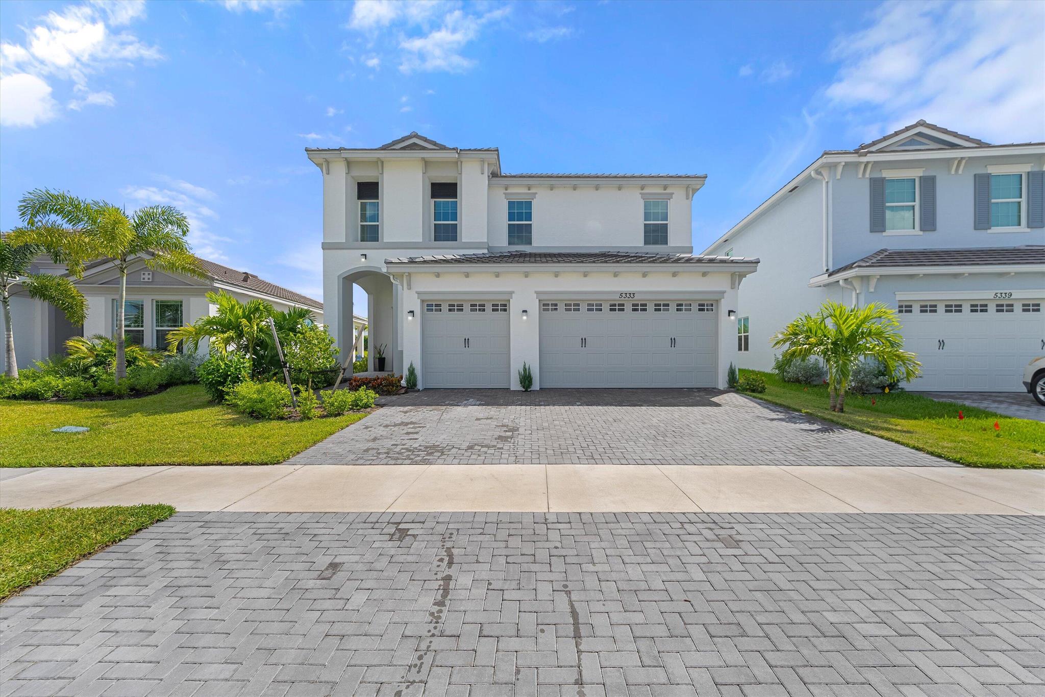Welcome to this stunning Laurel Model two-story home with a balcony in the highly sought-after Orchards community in Westlake, Florida. With four bedrooms + Loft , three bathrooms and a three-car garage, this residence is filled with numerous upgrades and exudes a clean, modern aesthetic. As you approach the striking black double entry doors, the sense of luxury is immediate. Inside, the living area greets you with glossy white floors, soaring ceilings, and an abundance of natural light, enhancing the open and airy feel.
