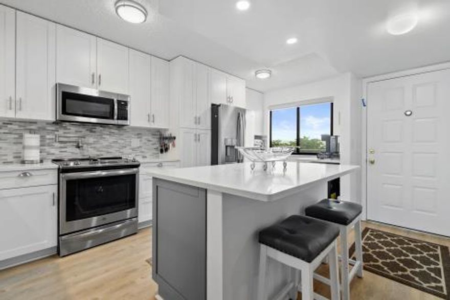 Totally upgraded 2 bedroom 2 bathroom unit in 55+ community. Condo features shiplap entry, waterproof vinyl floors, designer lighting, screened balcony. Storage and sliding Hurricane windows. New a/c, water heater, plus all-appliance warranty through June, 2025. New bathrooms. Deep tub. Chef's kitchen features stainless steel appliances, range with pot-filler above, coffee station, side-by-side refrigerator with door dispenser and large island with storage below.  All surfaces feature quartz. View of the pond and one of the two community pools. Clubhouse for entertaining, library, card and pool rooms, sauna adjacent to the 2nd, large swimming pool. Close to all amenities including restaurants, markets, doctors and Okeeheelee Park. Proof of funds and mortgage approval to accompany offers.