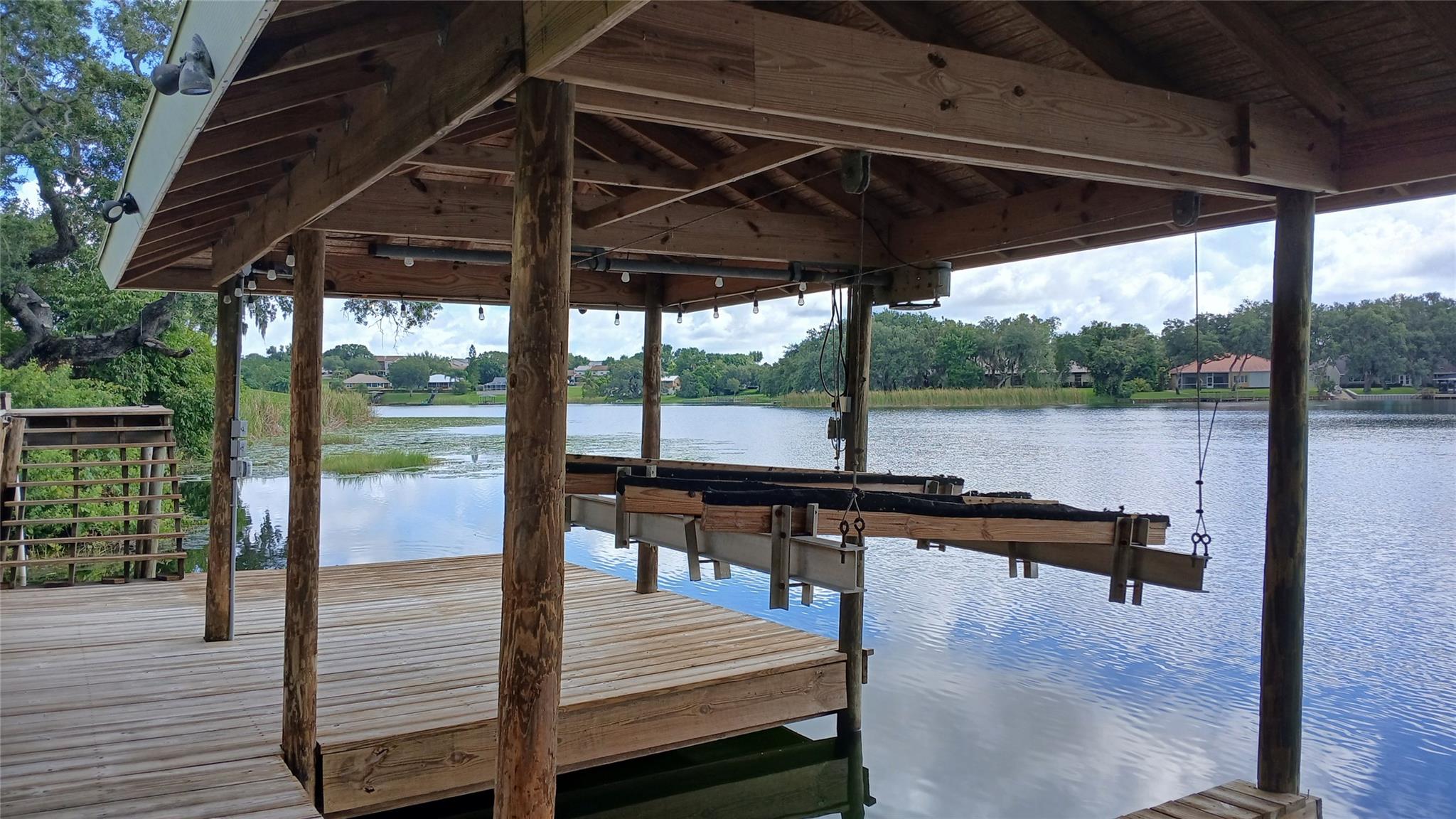 Amazing Lake Views throughout this 3 Bedroom 2 1/2 Bathroom home with an Open Air Balcony and Screened in Patio directly beneath. This unique style home has a guest suite downstairs complete with living room, full bathroom, wet bar and a screened patio. Roof was replaced in 2018, Main A/C and Water Heater in 2024. This home can be sold furnished. Located within the Town limits of Lake Placid and less than 1 mile to Publix, Restaurants and Shopping. Large Dock with Electric that features 2 watercraft areas 1 with a lift set up for 2 personal watercraft and the other open to dock a smaller size boat under the roof. Schedule a showing today!!