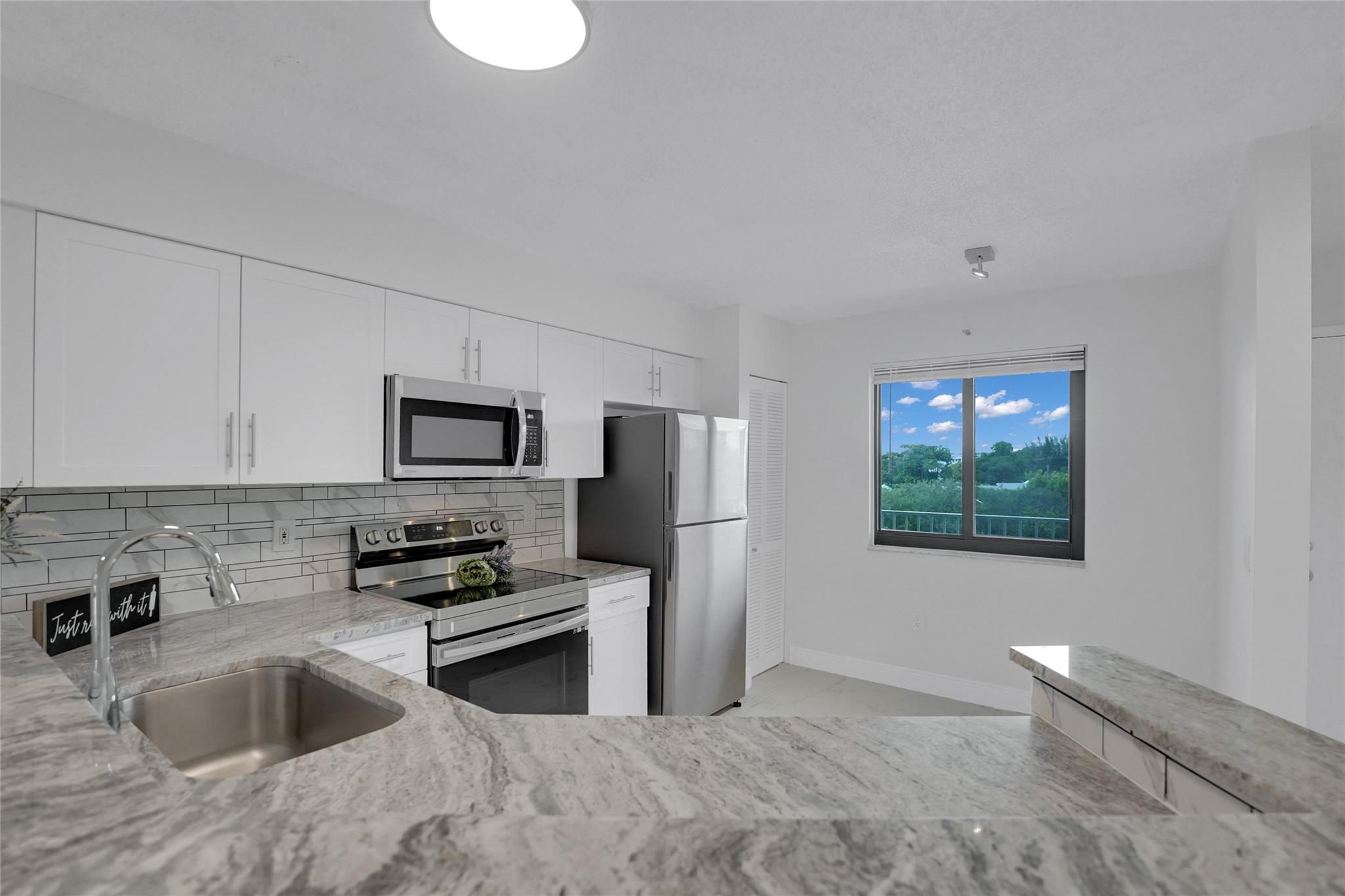 2 bedroom 2 bath with views of the lake and the complex area. Brand new polished porcelain tiles throughout, new impact windows with screens and sliding doors, updated open kitchen with granite counter, updated modern bathrooms, brand new never used stainless steel appliances and new never used washer dryer in unit. Unit is freshly painted and in turn key condition. This all ages community features walking biking trails, tennis, pickleball courts, pools, hot tubs, clubhouse, library, BBQ areas, pet friendly, fitness center, meeting card room and more. Vacant and easy to show.