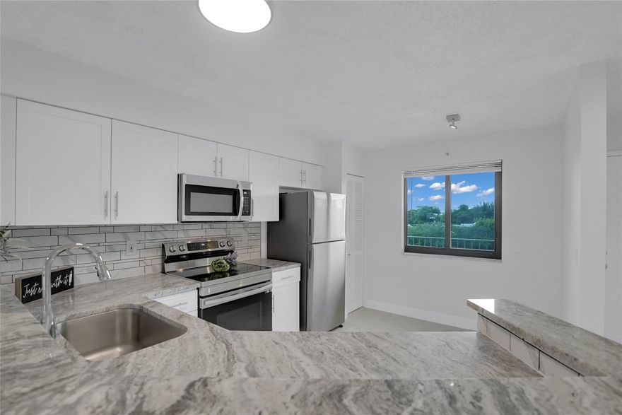 2 bedroom 2 bath with views of the lake and the complex area. Brand new polished porcelain tiles throughout, new impact windows with screens and sliding doors, updated open kitchen with granite counter, updated modern bathrooms, brand new never used stainless steel appliances and new never used washer dryer in unit.  Unit is freshly painted and in turn key condition. This all ages community features walking biking trails, tennis, pickleball courts, pools, hot tubs, clubhouse, library, BBQ areas, pet friendly, fitness center, meeting card room and more. Vacant and easy to show.