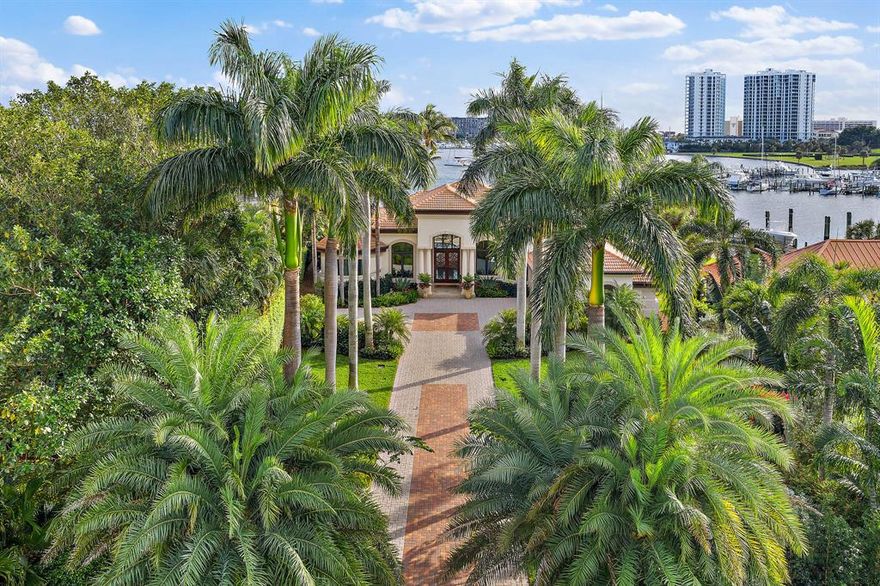 STUNNING Intracoastal water views with perfect southern exposure in this beautiful one-story estate home. Highly sought after small gated water community with light and bright volume ceilings and open floor plan. Tropical Palm Beach, treelined driveway brings you to the grand entrance which offers recent updates inside and out! All new PGT impact windows and sliding doors. A new dock featuring (2) 40 foot boat lifts for an 18k and 25k lb boat and additional dockage for up to 100ft yacht. Full home generator, 3 new top of the line Lennox HVAC systems. The transitional decor with marble floors throughout is complimented by a gourmet chef's kitchen w/Viking gas range, commercial cook top hood, and 2 Bosch dishwashers. Spacious master suite with tranquil water & skyline views offers