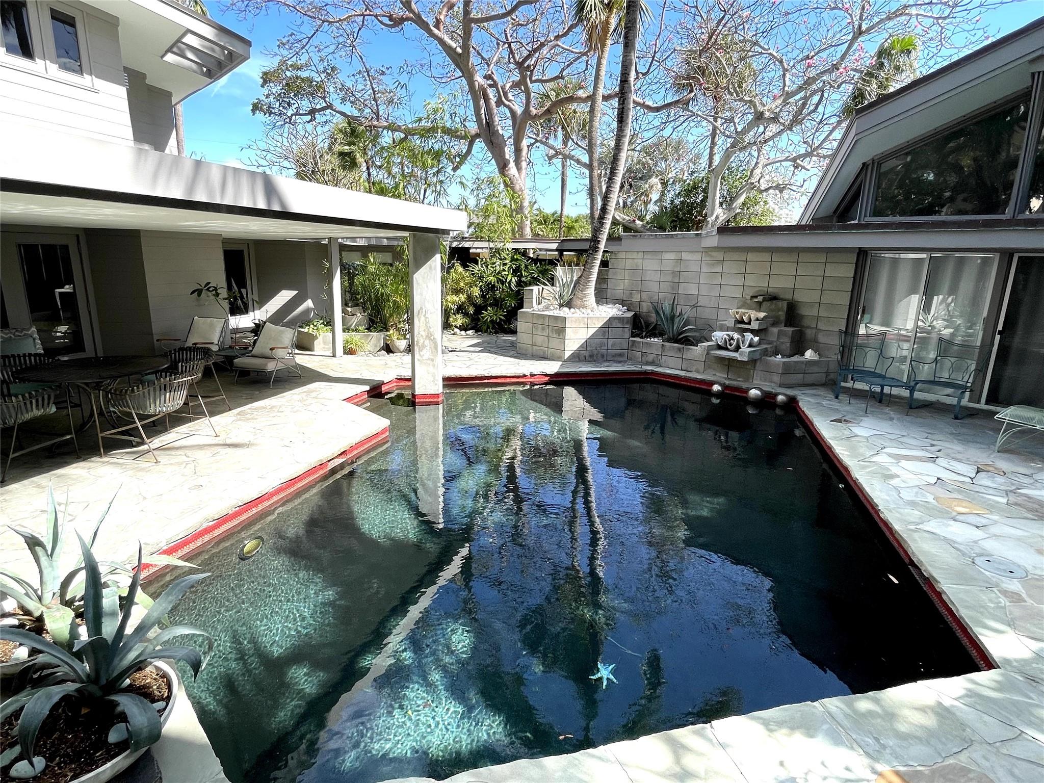 Nestled in the Bel Air neighborhood steps to the ocean is a Mid Century Modern gem by architect Dan Duckham. The home was designed and built in 1963 inspired by Frank Lloyd Wrights "Hanna House" in California. One enters a tropical garden with mature exotic trees forming a canopy over a central lagoon pool. The home has been meticulously restored and enhanced to include new: Fisher Paykel appliances - marble and concrete countertops- electrical- Hvac- plumbing-pool pump-pool lights-outdoor Blaze grill powered by natural gas-tankless water heater gas- washer- security system-super gutter-fascia boards-cabinetry- custom closet doors.
Most original design remain including terrazzo & large slab stone floors- WB fireplace-floating aluminum staircase -concrete countertops and dining table.