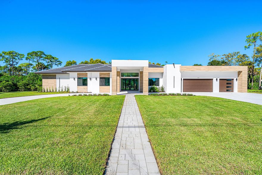 Step inside this exceptional 2025-built modern one-story estate in Wellington, where elegance meets contemporary design. Behind impressive double doors, you'll find 5 spacious bedrooms, 6.5 luxurious bathrooms, a private office, and a 3-car garage. The open layout is thoughtfully designed with exquisite finishes and expansive impact windows that frame stunning views of the lush backyard. At the heart of the home is a gourmet kitchen with premium Dacor appliances, a gas cooktop, and custom cabinetry, ideal for daily living and entertaining. For comfort and efficiency, the estate includes three central A/C units, an instant hot water system, and a well water irrigation system. Connected to city water and sewer, this home offers added convenience with no septic maintenance required.