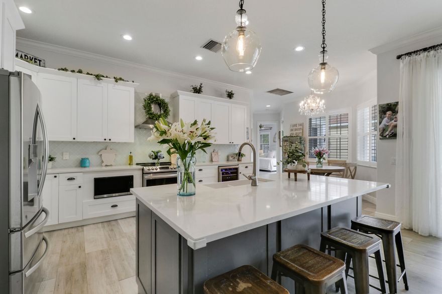 Bright, inviting, and ideally situated, this courtyard-style B-Model home in NewHaven at Abacoa—built by Divosta Homes in 1999—offers 3 bedrooms, 2.5 baths, and a 2-car garage, along with tranquil preserve views from its charming front porch. Inside, a thoughtfully designed open-concept layout features tile flooring throughout, plantation shutters, and a beautifully renovated kitchen that has been opened up to enhance flow and functionality. The kitchen includes a center island, quartz countertops, upgraded appliances, modern lighting, and a sleek glass backsplash. The spacious living area is perfectly suited for both entertaining and everyday living. The primary suite offers a true retreat, complete with a spa-like bathroom featuring quartz countertops and dual shower heads with handhelds & body sprayers for a luxurious experience. Step outside to a private side yard designed for low-maintenance enjoyment, featuring artificial turf and a fun mini putting green—ideal for relaxing or casual play. Recent updates: roof replaced in 2022,  4-ton A/C unit replaced in 2021 and primary bathroom remodeled in 2025, providing added comfort and peace of mind.  NewHaven is widely regarded as one of the premier neighborhoods in Jupiter, consisting of 405 single-family homes and 100 townhomes, and offering a true sense of community. Residents enjoy a well-maintained environment with HOA benefits that include exterior painting (completed in 2025), cable TV and high-speed internet through Hotwire, exterior pest control, and landscaping. Community amenities include two pools with heaters for the winter months and chillers to keep them refreshing in the summer, a brand-new fitness center, 2 playgrounds for the kids, clubhouses, scenic walking trails, and a newly added covered park. All just minutes from pristine beaches, top-rated schools, golf, shopping, dining, downtown Abacoa, and Palm Beach International Airport.