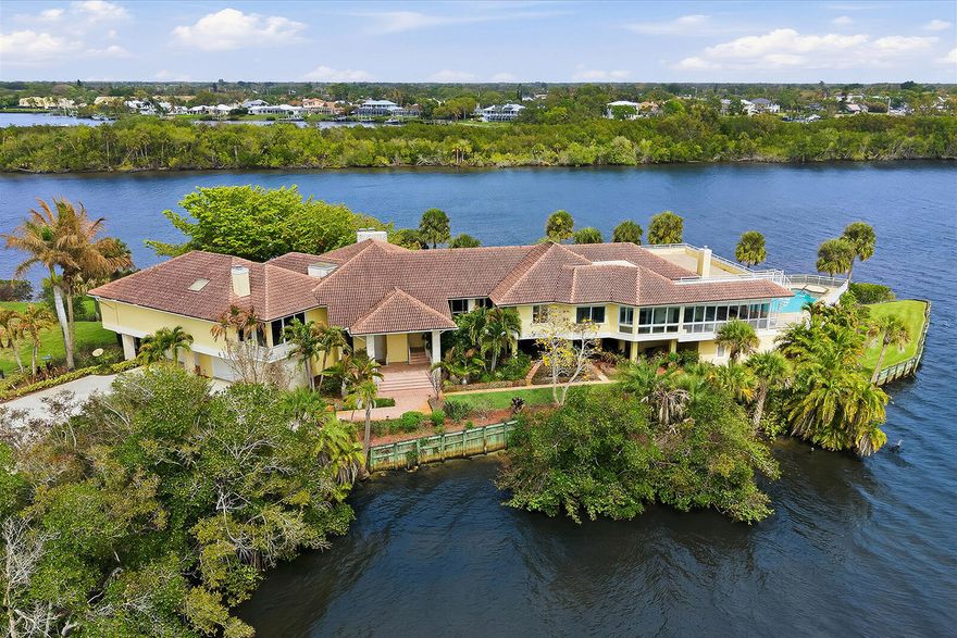 The Peninsula Estate is gracefully set upon more than an acre of land with approximately 650 feet of extraordinary water frontage, offering one of the most private and captivating waterfront settings along Florida's coveted Treasure Coast. Positioned on a rare peninsula within the exclusive gated community of Bay St. Lucie, the property is surrounded by sweeping panoramic views of the St. Lucie River, creating the feeling of a secluded island retreat. The residence encompasses over 8,467 square feet of refined living space, thoughtfully designed to capture the beauty of its surroundings. Elegant marble flooring, expansive living and entertaining areas, a gourmet kitchen, and a distinguished library with fireplace reflect both comfort and sophistication. Walls of glass frame spectacular .. river vistas from nearly every room, seamlessly connecting the interior spaces with the serene waterfront landscape. A separate guest residence offers private accommodations ideal for extended family or visiting guests. The estate's expansive grounds and remarkable peninsula setting present exceptional possibilities for a private family compound, executive retreat, or luxury waterfront sanctuary. Outdoors, a private docks w/30,000 & 10,000lb boat lifts and resort-style pool overlook the tranquil waters of the St. Lucie River, completing this extraordinary waterfront offering. The Peninsula Estate represents a rare legacy property where privacy, scale, and natural beauty converge. Additional details and property information available in the MLS.