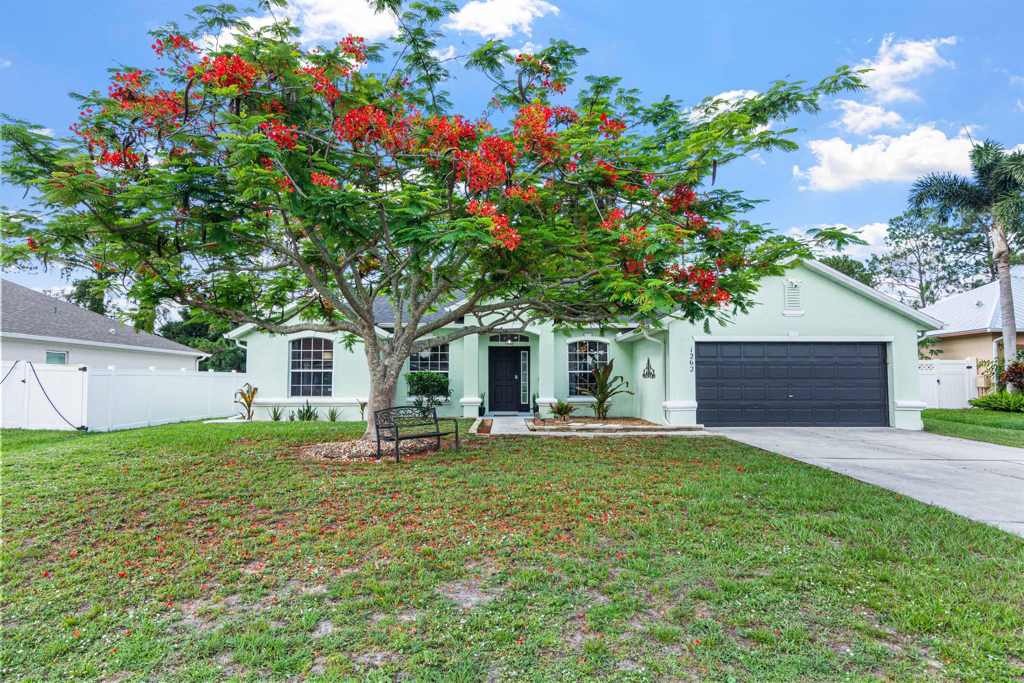 Room for everyone in this true 4 Bedroom, 3 Bath, 2 car garage home! 2023 ROOF! Designated living & dining rooms w/kitchen that overlooks spacious family room. Breakfast nook features picture window w/ built in seating & offers a great view of the expansive backyard w/beautiful mature oak tree! Rich looking wood laminate flooring in living areas and master bedroom. Upgrades include arched doorways, plant shelving, tray ceiling in Master bedroom & rounded corners. Located on interior drainage canal for added privacy from the neighbors. Exterior painted in 2020. Great location w/easy access to I-95 & Florida's turnpike. 2 Royal Poinciana trees add to the beauty of the outdoor living space. No HOA! SELLER WILL GIVE $10,000 CREDIT to buyer for rate buy down, updating or closing costs.