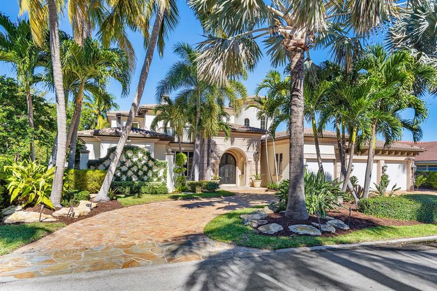 215 Coconut Palm Road is a Mediterranean-inspired waterfront estate located on Butterfly Palm Waterway in Royal Palm Yacht & Country Club just a short wake from direct Intracoastal and Ocean access. The home features 5 bedrooms, 6 full and 1 half bathrooms, 6,302 sq ft under air, and a 3-car garage. The open-concept floor plan has a first-floor carpeted master suite with his and her baths, walk-in closets, and dressing areas, a formal dining room with custom lighting, a grand two-story formal living room with a gas stone surround fireplace, private study, and beautiful gourmet kitchen. The second-floor bedrooms are all ensuites with walk-in closets and have two large stone sunning decks. Enjoy outdoor living all year long in the resort-style backyard with heated infinity-edge pool and spa fountains, travertine paver deck, and BBQ-equipped covered summer room. Perfect for the boating family, this home has 100' of water frontage with no fixed bridges, and includes a large wooden dock with power and water.